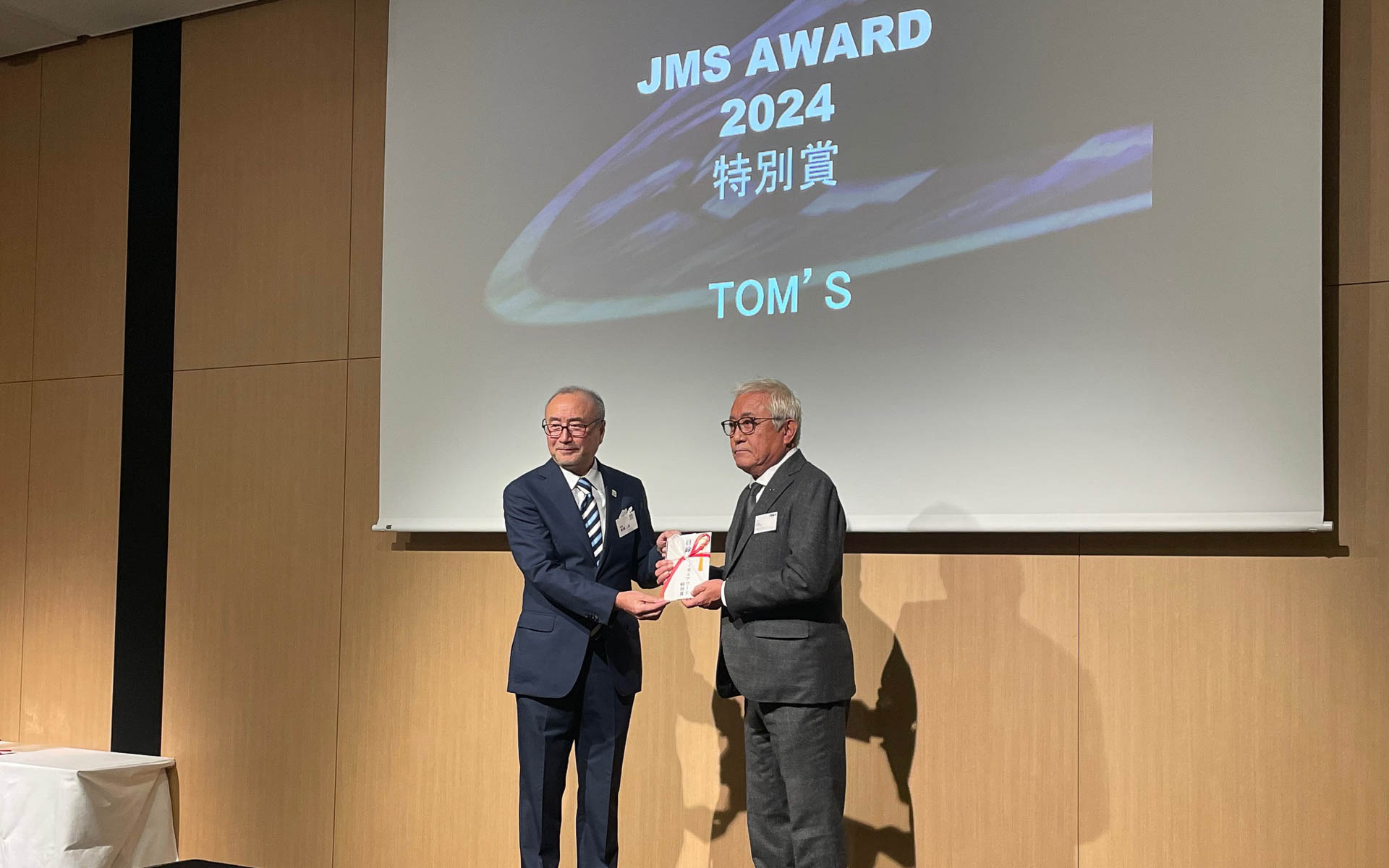 特別賞の舘信秀さん。昨年トムス創業50年を経て大きく飛躍した年でもあった。そしてSUPER GTとスーパーフォーミュラのチャンピオンを獲得した坪井翔選手を排出したのもトムスだった
