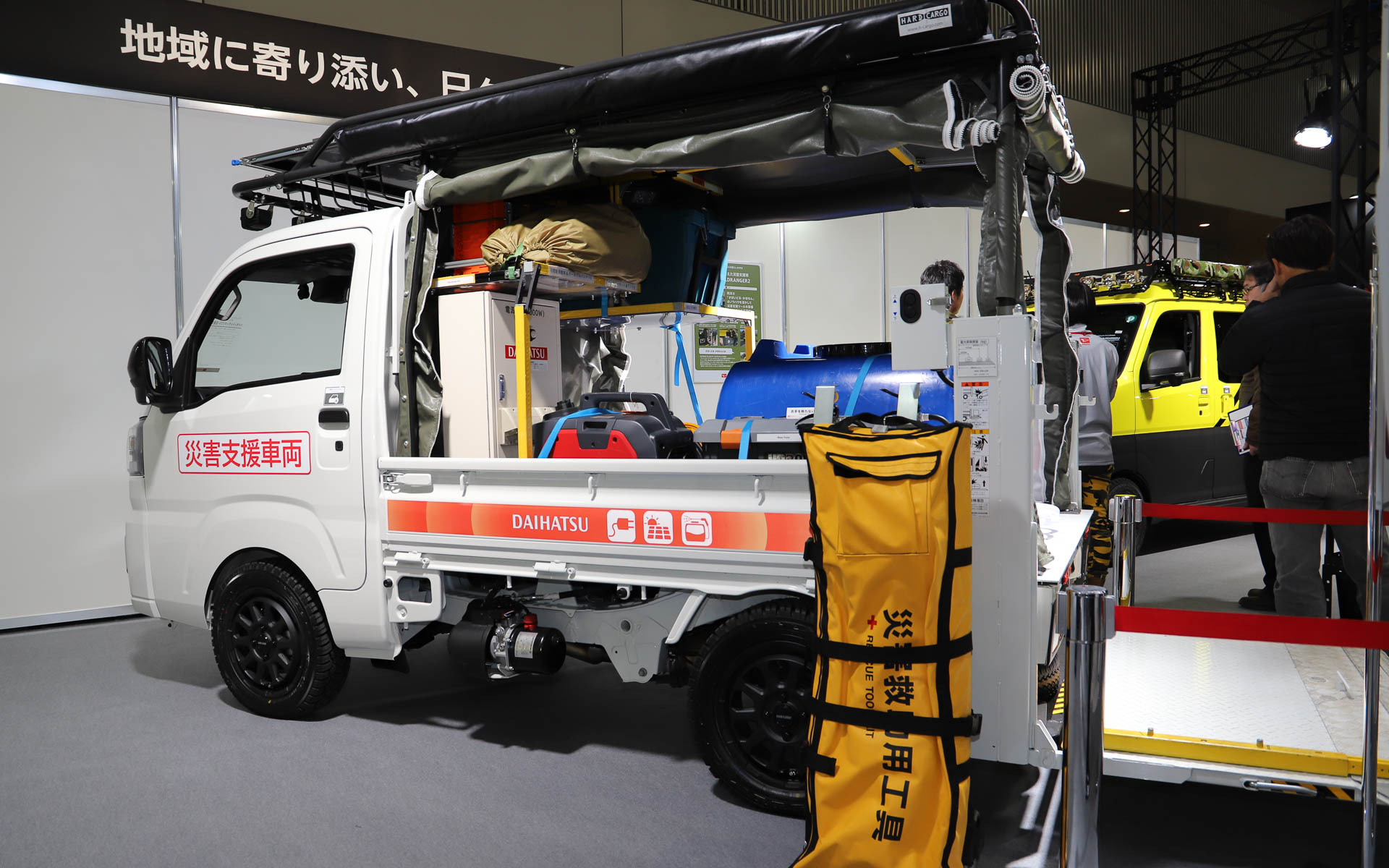 アトレー WILDRANGER2は実際に九州北部地域で現場復旧活動を支援。大きな荷物が載せ下ろしできるように垂直テールリフトをカスタムしているほか、さまざまな用途の復旧機材、更衣室にもなるテントを装備している