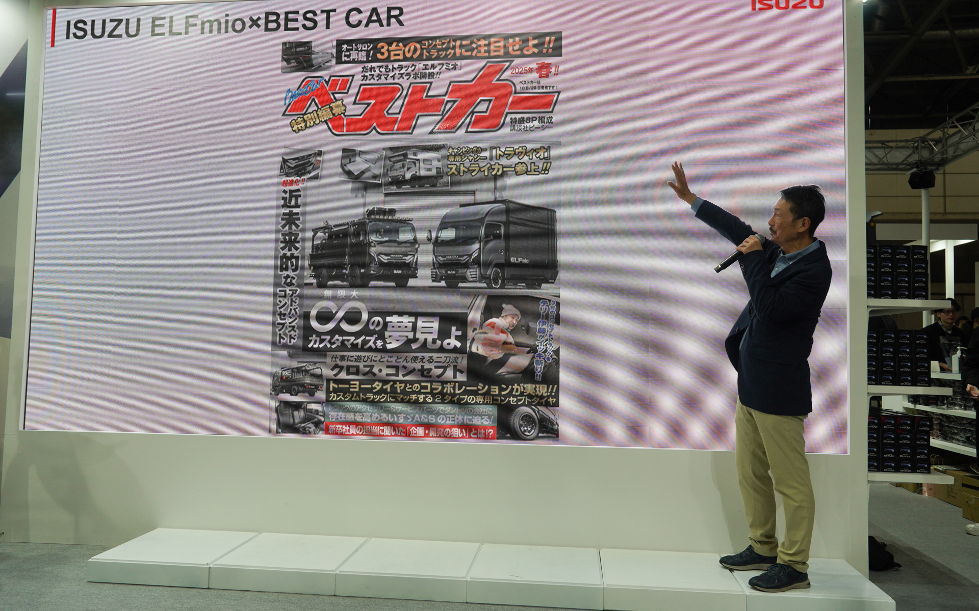 ベストカー編集部の梅木智晴氏が配布の特別号を説明