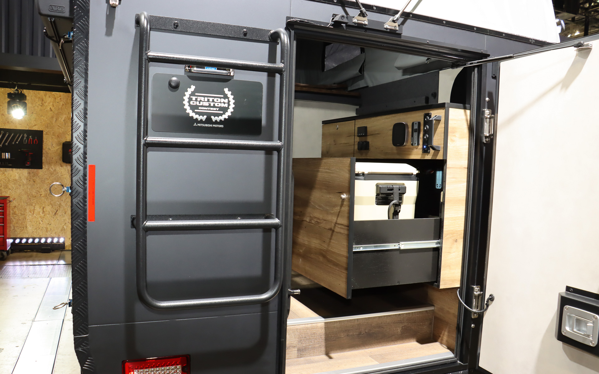 車両後方に冷蔵庫付きの本格的なキッチン、テーブル、エアコンなどを完備