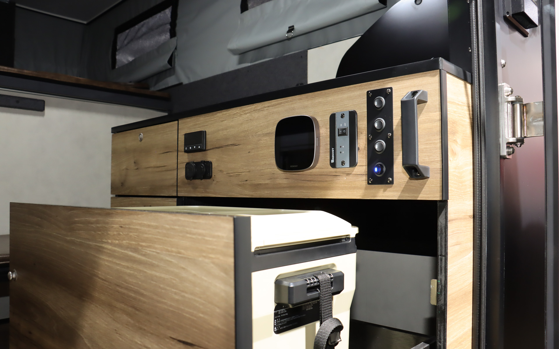 車両後方に冷蔵庫付きの本格的なキッチン、テーブル、エアコンなどを完備