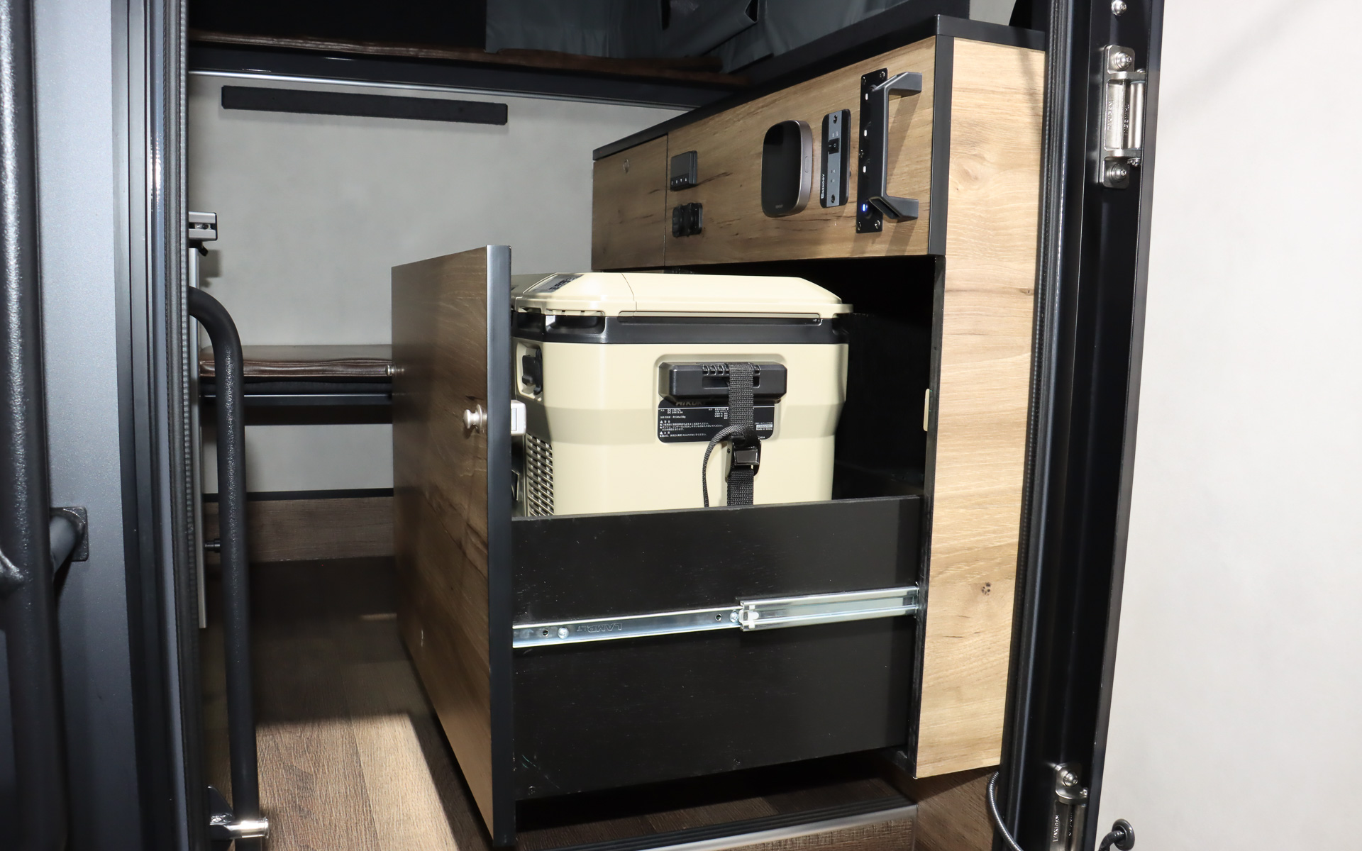 車両後方に冷蔵庫付きの本格的なキッチン、テーブル、エアコンなどを完備