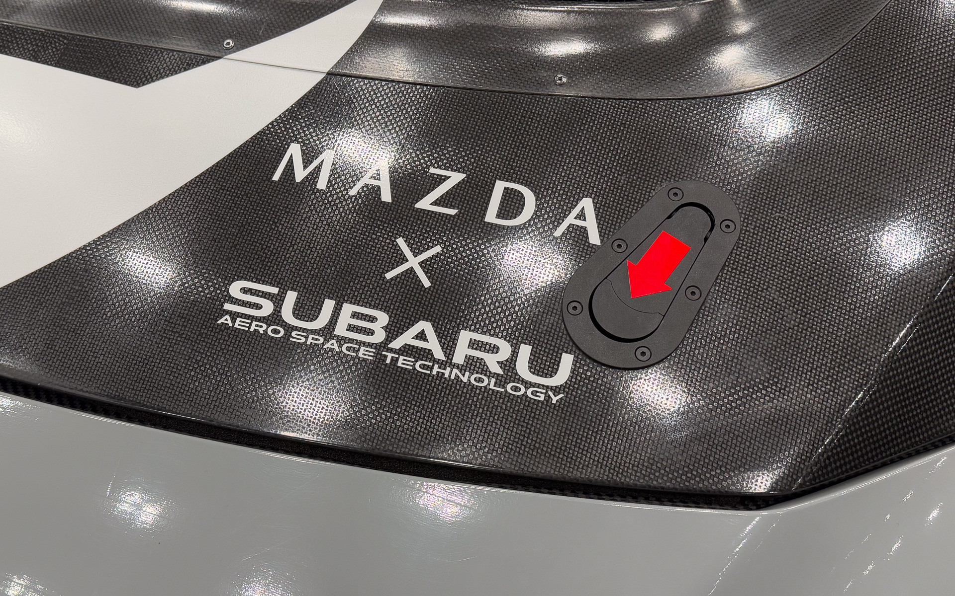 マツダ、スバルの協業であることを示すカーボン再生材を使用したボンネット