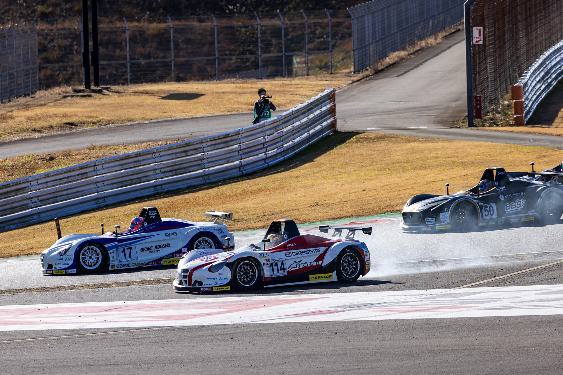 1コーナーのせめぎあいでは、予選トップの17号車 Team M 岡部自動車 D.D.R. VITA 斎藤愛未選手のイン側を狙いにいった2番手の114号車 Car Beauty Pro RSS VITAの翁長実希選手が、オーバースピードと冷えた路面でのブレーキングでタイヤをロックさせてしまいコース外へオーバーラン。いっきに順位を落とした