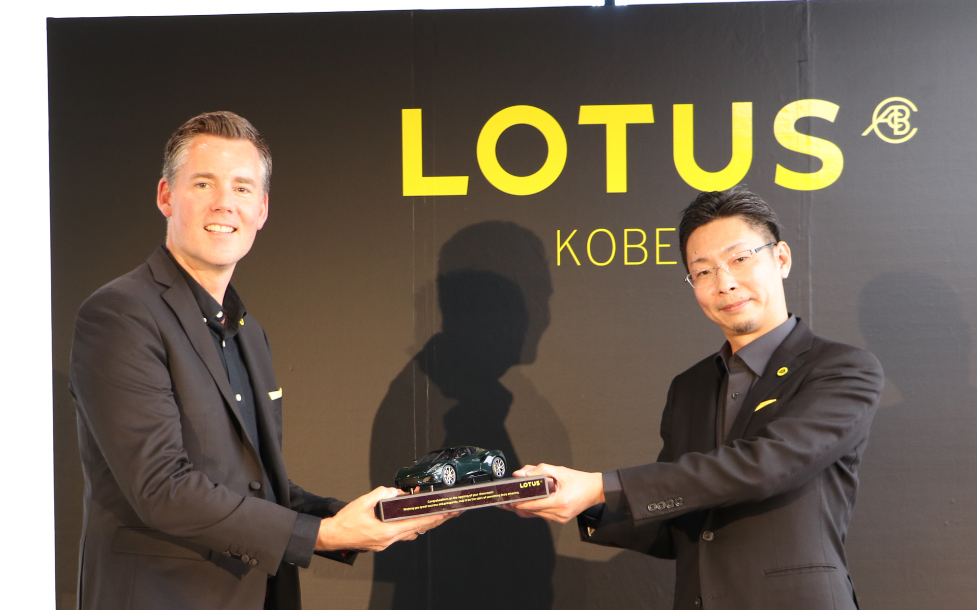 ロータス神戸のオープンを記念して、英ロータスから「エミーラ」のダイキャストカーが贈呈された。台座には開店祝いと商売繁盛の激励コメントが刻まれている