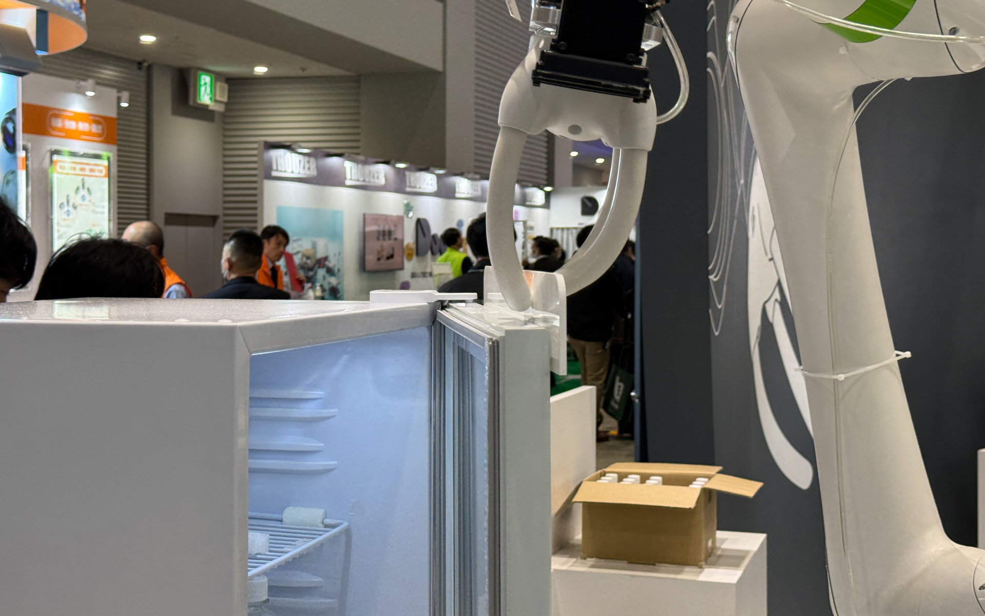 冷蔵庫の扉を開けてペットボトルを棚入れ