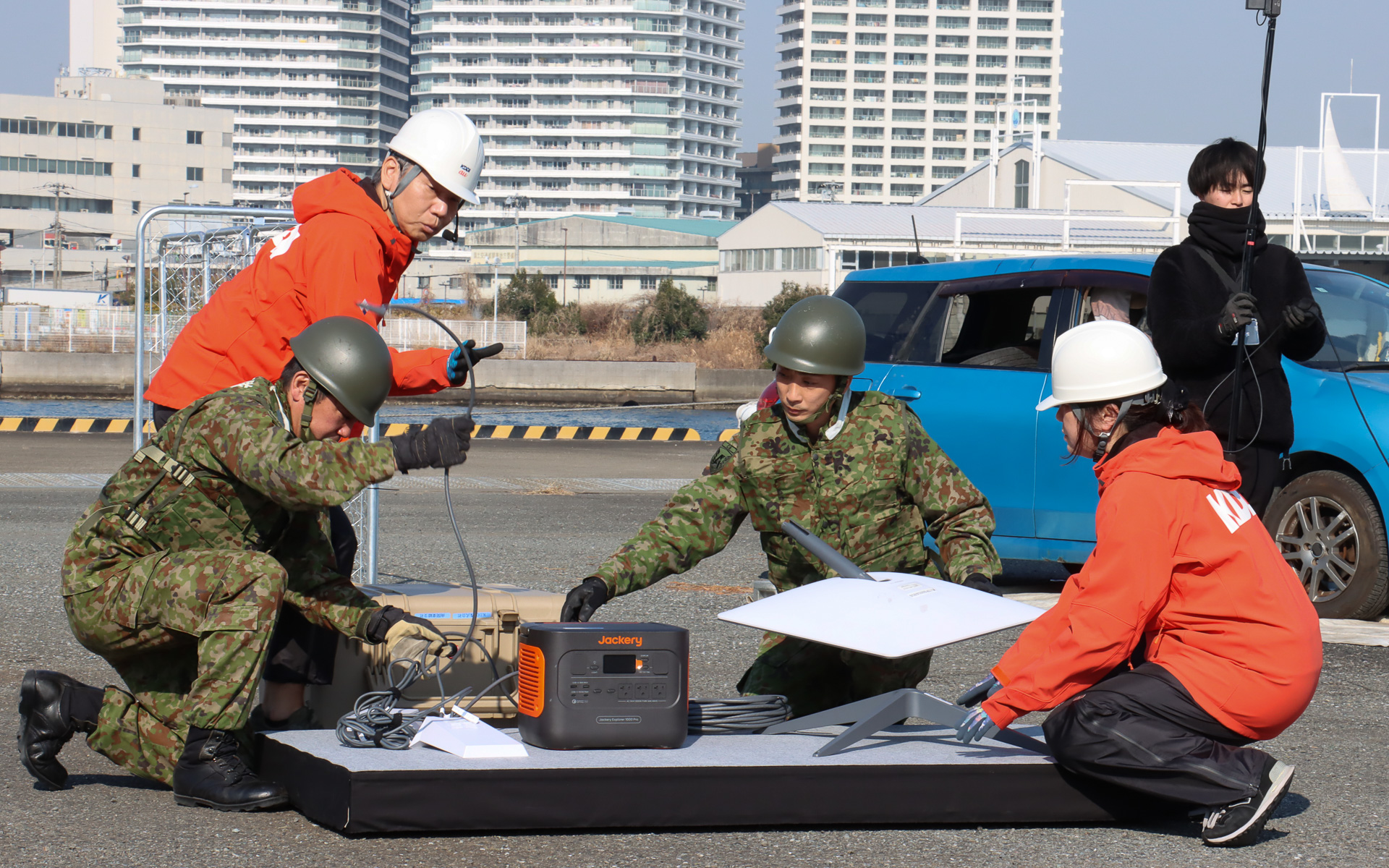 災害時の相互協力協定に基づき、自衛隊員とKDDIのスタッフがアンテナ展開、電源の確保を共同作業
