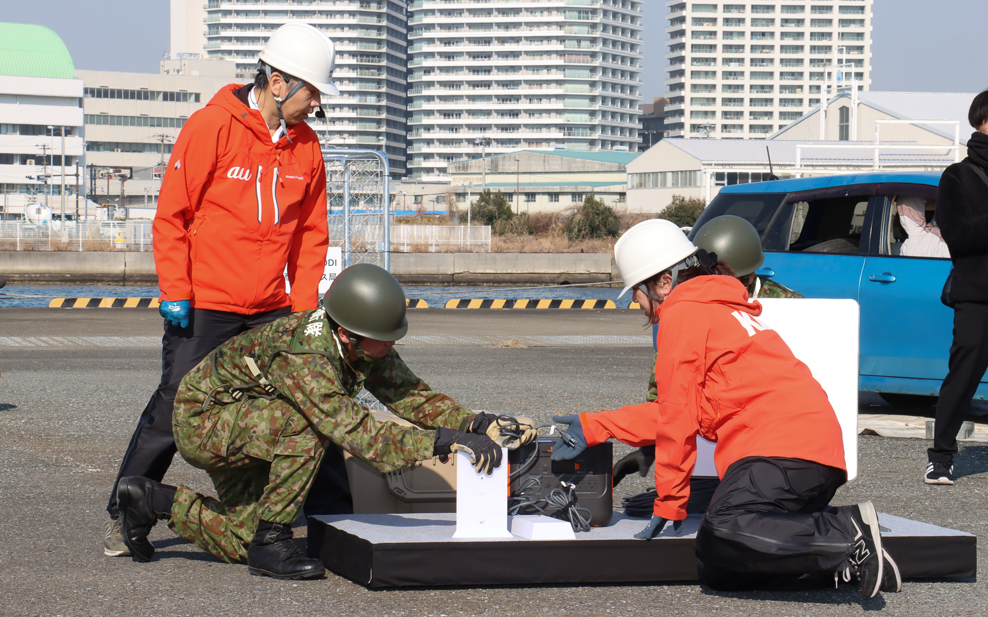 災害時の相互協力協定に基づき、自衛隊員とKDDIのスタッフがアンテナ展開、電源の確保を共同作業