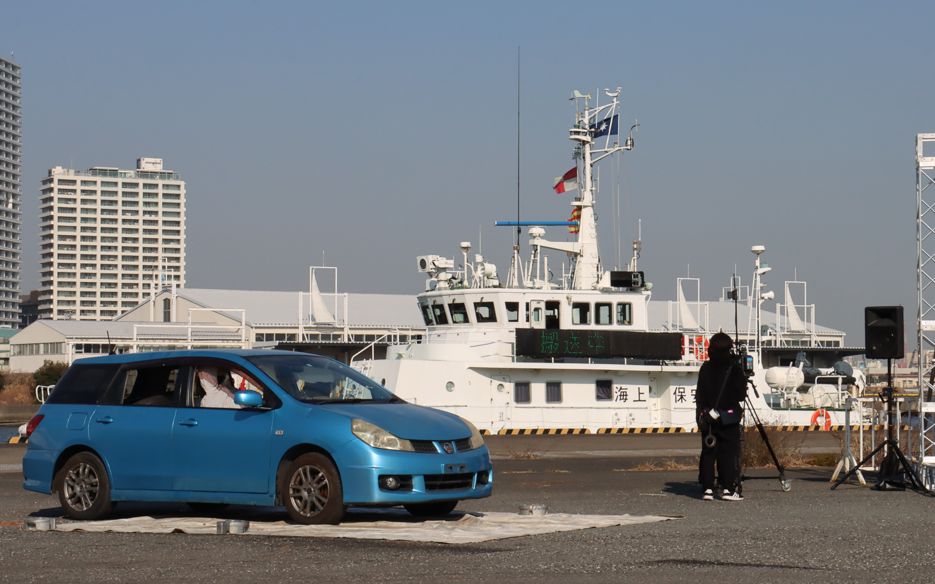 海上保安庁の巡視艇「はまなみ」からKDDI 現地復旧班が下船し、海上保安庁の職員からStarlink復旧機材を受領。雨や海水の影響で浸水被害が出ないよう、各機材は防水カバーで覆われている