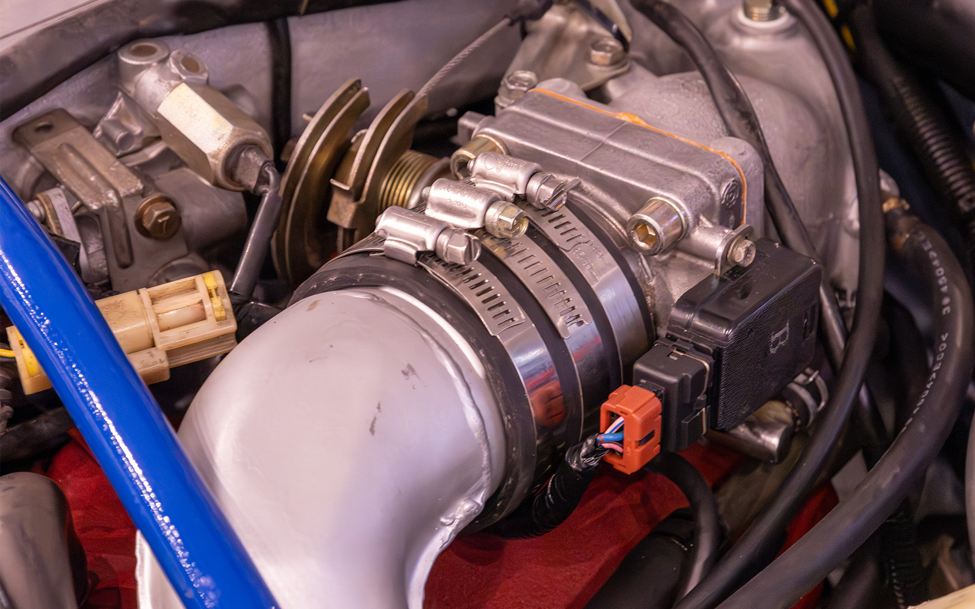 インテークパイプのゴム製ジョイントホースには、ブーストがかかった際にホースが内圧上昇で膨れるのを防ぎ、エンジンレスポンスを悪化させないために中間部にもホースバンドを掛かけている