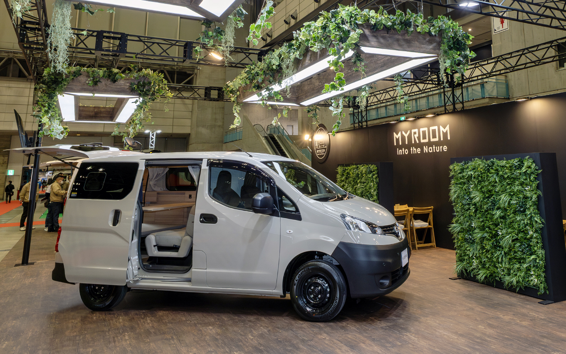 ジャパンキャンピングカーショー2025の日産ブースでは「キャラバンMYROOM」と、2024年12月に発売された「NV200バネットMYROOM」を展示している