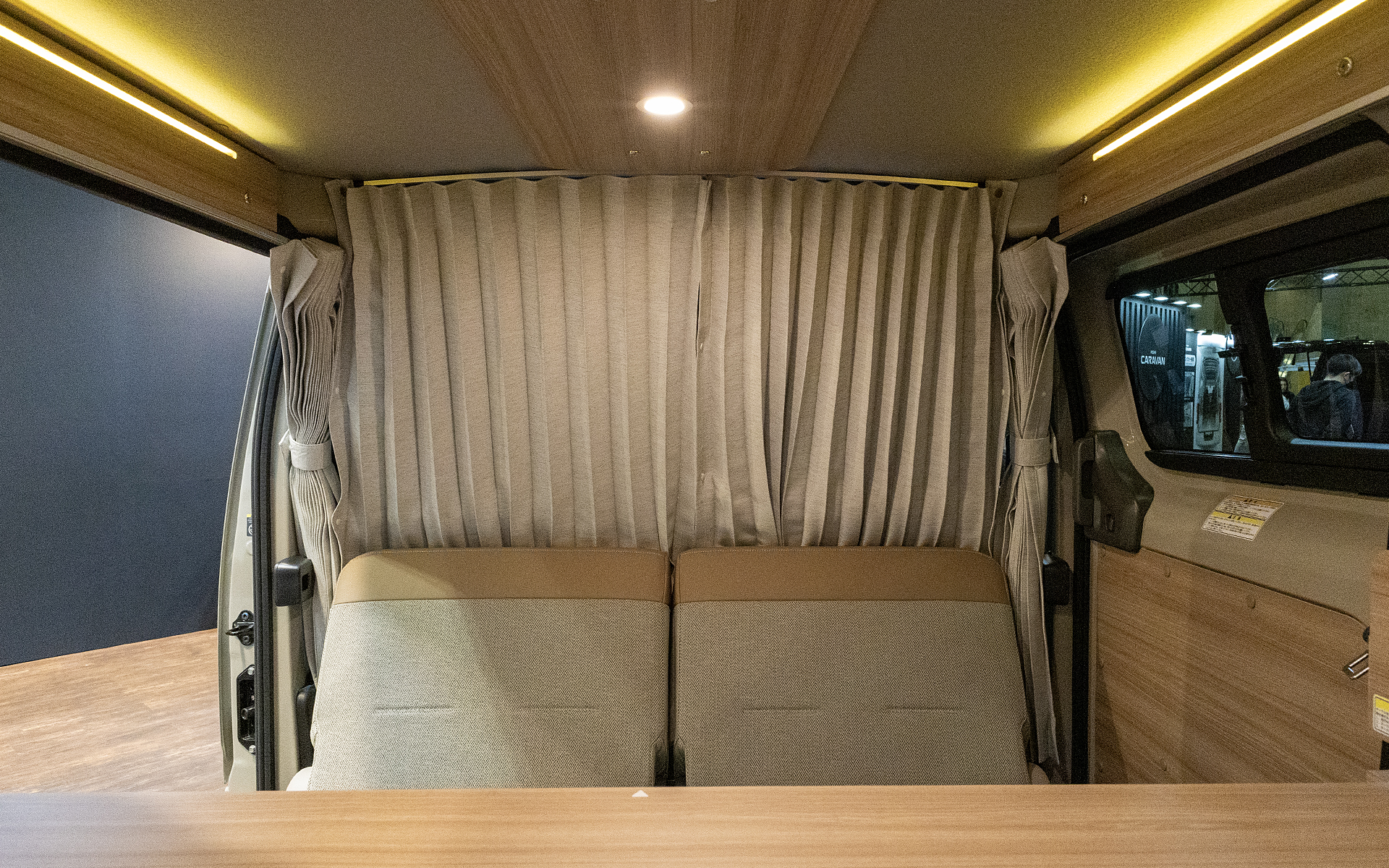 前席とリビングルームの境には遮光カーテンが装備される。天井には木目調パネルにスポット照明（調光機能付き）が備わる。また、サイドには間接照明も付く。照明のパネル類は角が丸く処理してあるが、こういった部分も単に丸めるだけでなく、デザイン的にもキレイなものになるよう考えられている