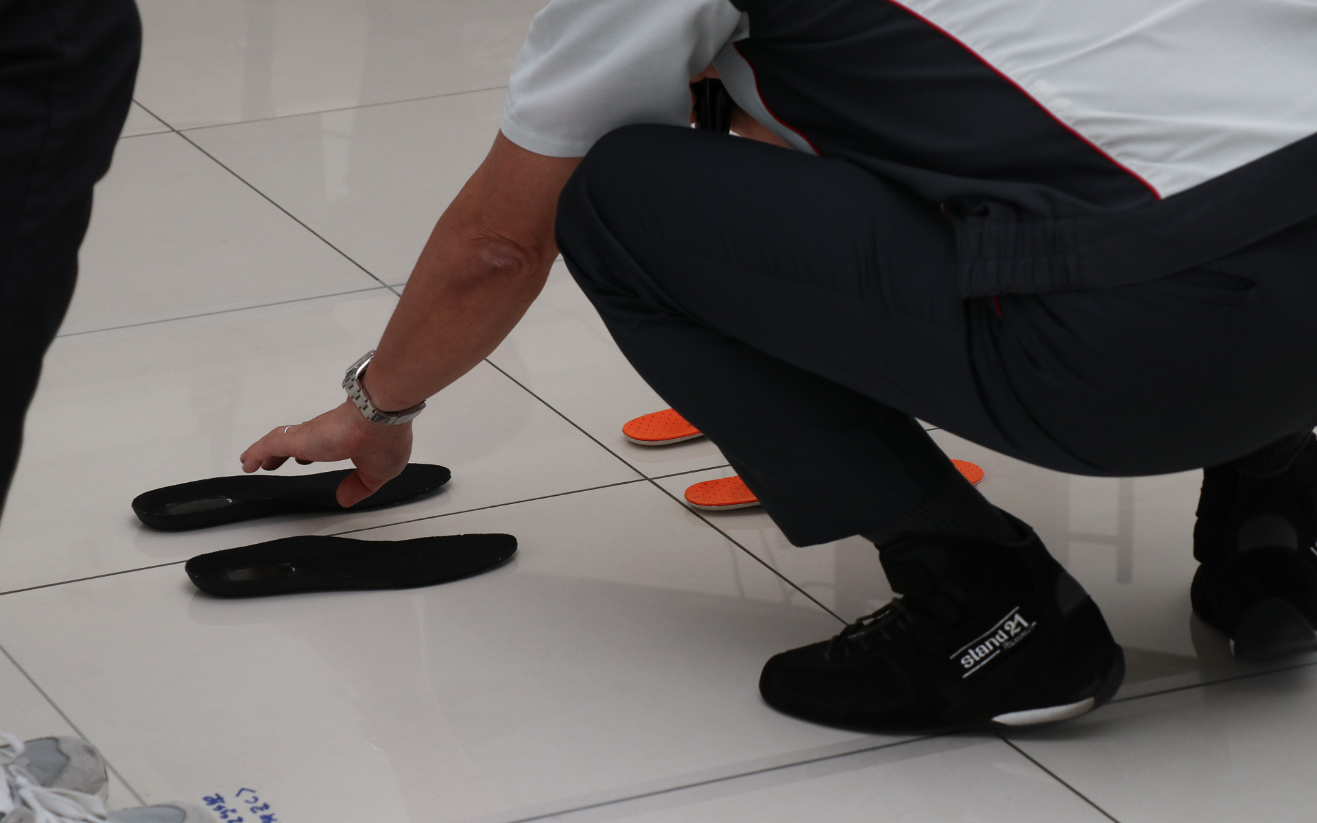 最初のレッスンは、一般的な靴の中敷きとBMZのインソールの上に靴を脱いで立つ体験。オレンジ色の製品がBMZのインソール