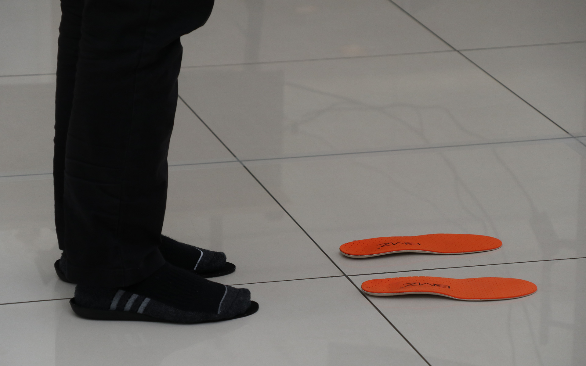 最初のレッスンは、一般的な靴の中敷きとBMZのインソールの上に靴を脱いで立つ体験。オレンジ色の製品がBMZのインソール