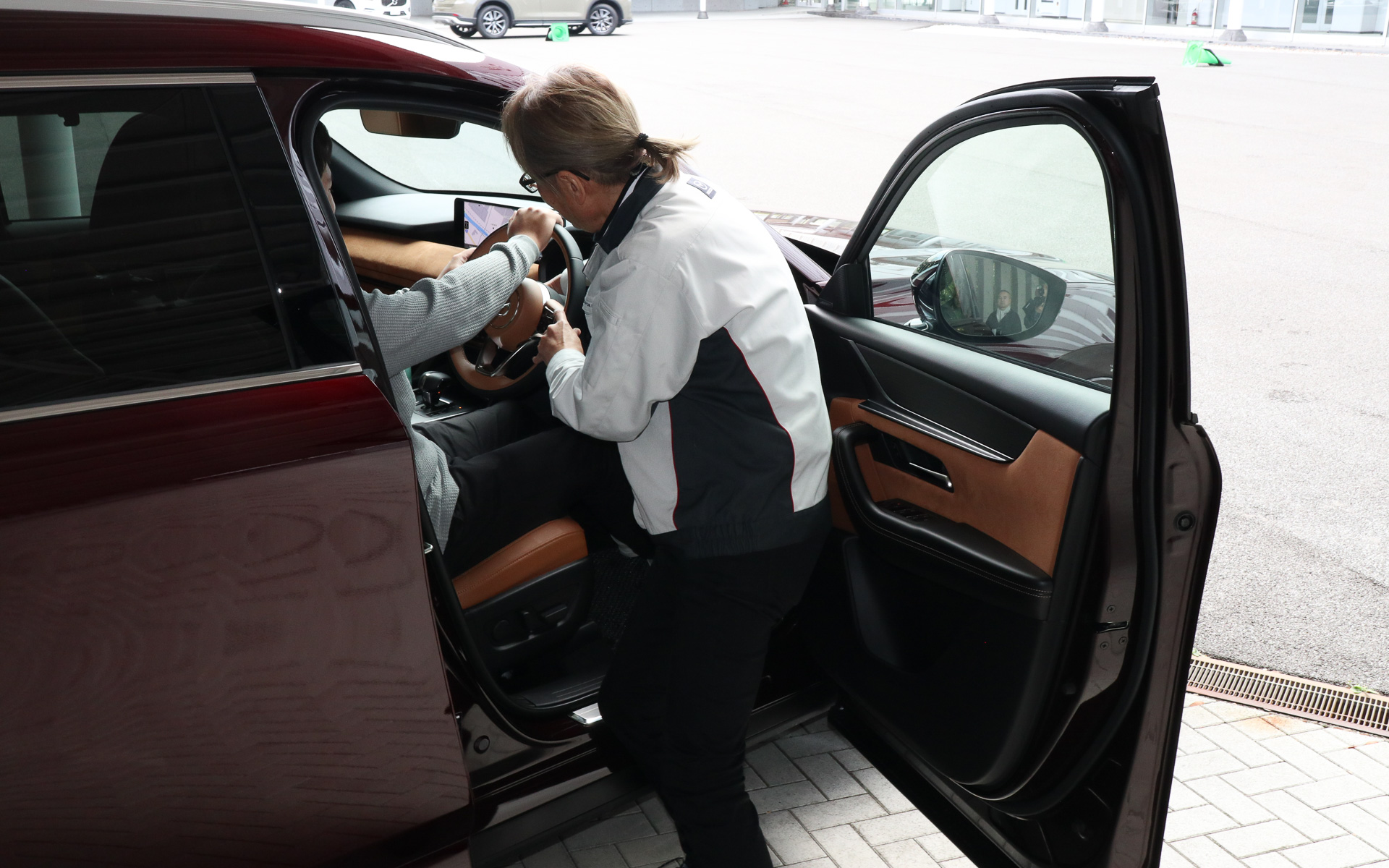 参加者の体格と車両の関係を確認しながらシートポジションやステアリング位置を調整。腕は直進中にリラックスできて、ステアリングを180度回転させても肘が伸びきらないことが重要