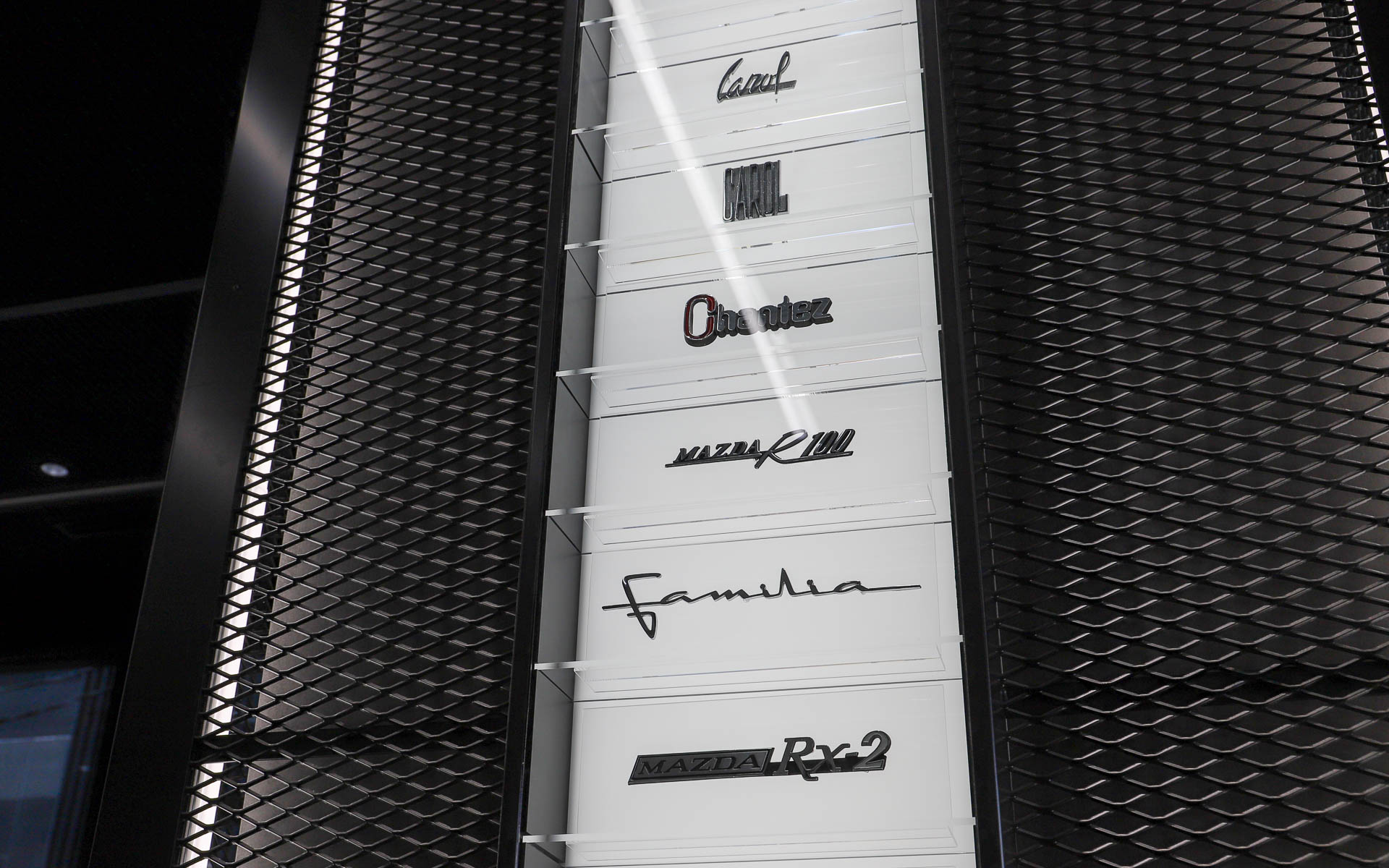 マツダ車のエンブレムやミニカーが壁面に飾られている