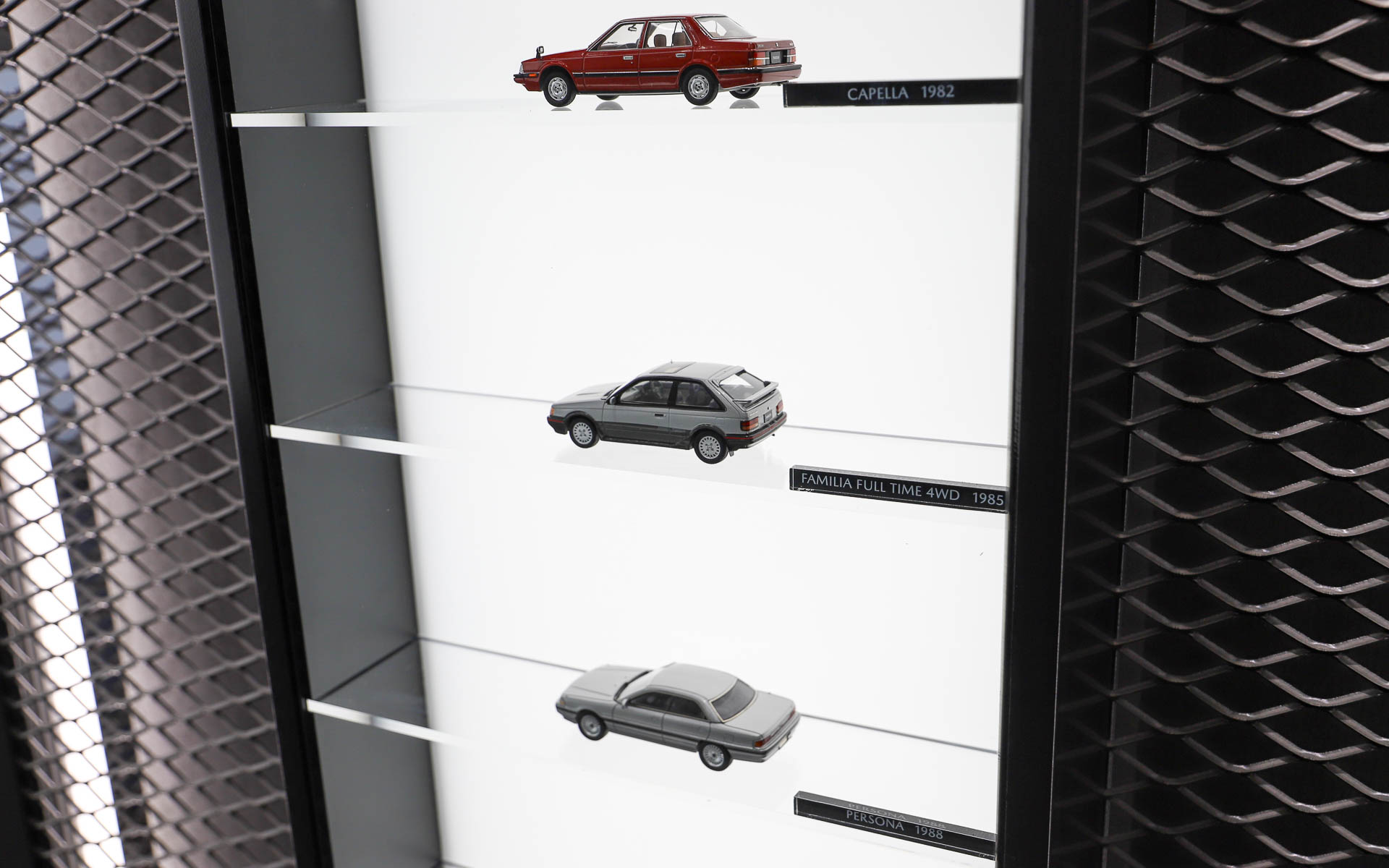 マツダ車のエンブレムやミニカーが壁面に飾られている