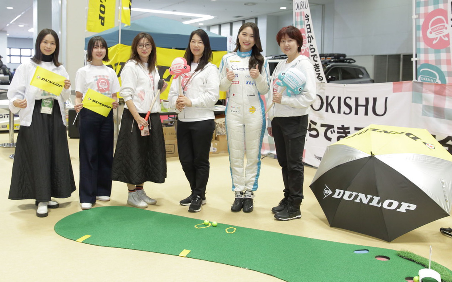 大阪オートメッセ2025の「OKISHU×DUNLOP」ブースでは、6名の女性で4つのコンテンツをお届けしました！　右からセーフティドライビングインストラクターの戎南子さん、歯科医師でありミスユニバースジャパン2022準グランプリのレーシングドライバー・及川紗利亜さん、私・カーライフジャーナリストのまるも亜希子、カーライフエッセイストの吉田由美さん、自動車ライターの瀬イオナさん、住友ゴム工業広報部の椎名真子さんです