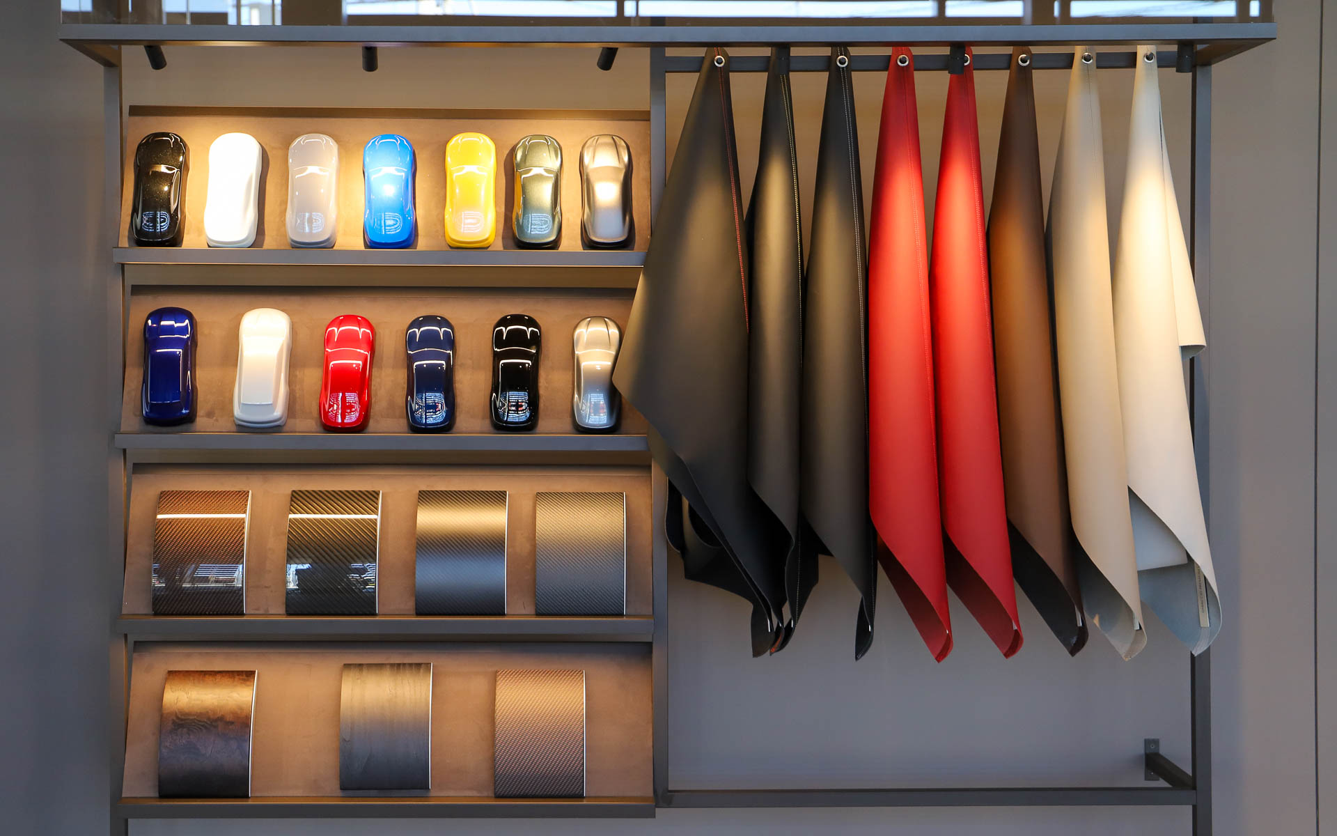 店内の壁面にはアパレルのほか、ボディカラー見本、ハンドクラフトレザーのサンプルなどが並ぶ。このほか、個室のコンサルテーションルームが用意され、最先端のMXE 3Dデジタルコンフィギュレーターを大型スクリーンで体験できる