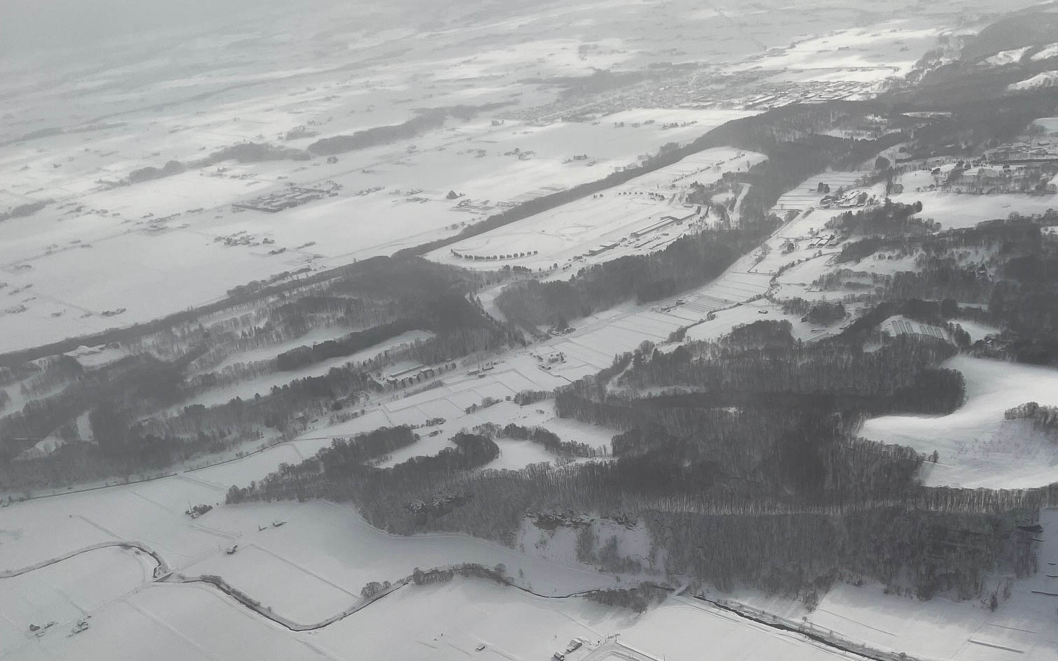 旭川近郊。東京から飛行機で約1時間半飛ぶと白い世界が広がっている。それでも黒い部分がいつもより多い