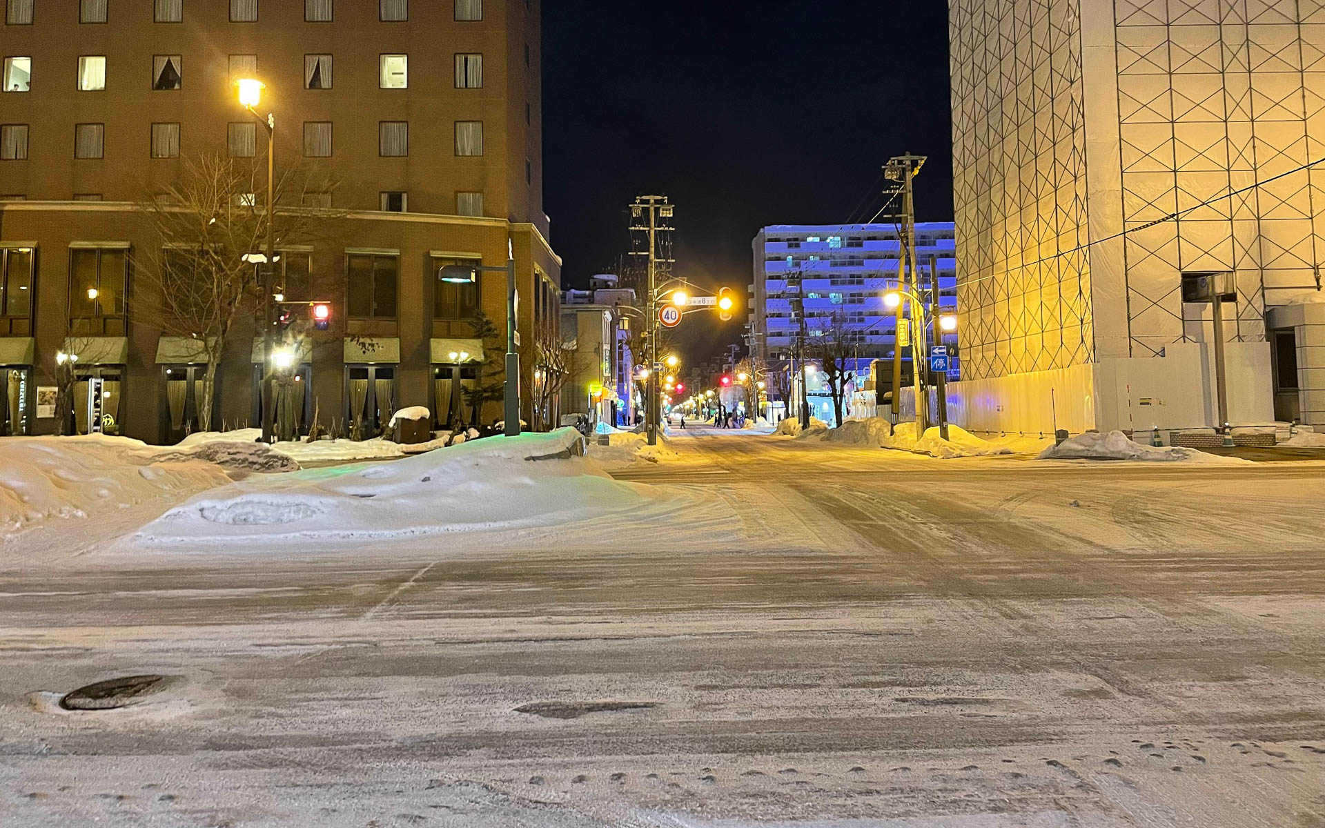 夜の旭川市街。路面は一部アイスバーンになっている。昼間は例年より雪が重い。インバウンド需要でホテルも予約しにくくなっている