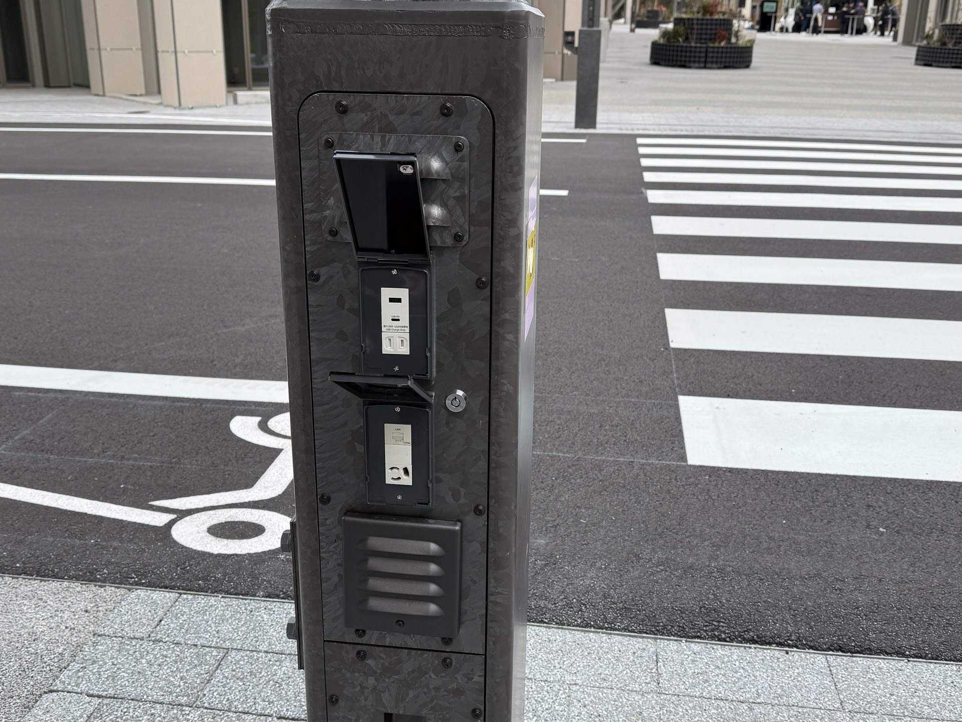 スマートポール基部には電源ユニットや通信線が用意されていた。上のブロックは電源系と思われ、USB-AやUSB-C PD、AC。下は通信系で、RJ-45と3PのAC。この中でエッジコンピューティングをすると説明しており、RJ-45はスイッチングハブではなく、パケット監視のためのダムハブにつながっているのかもしれない。3P ACとなっているのは、ノイズ対策のためだろうか？