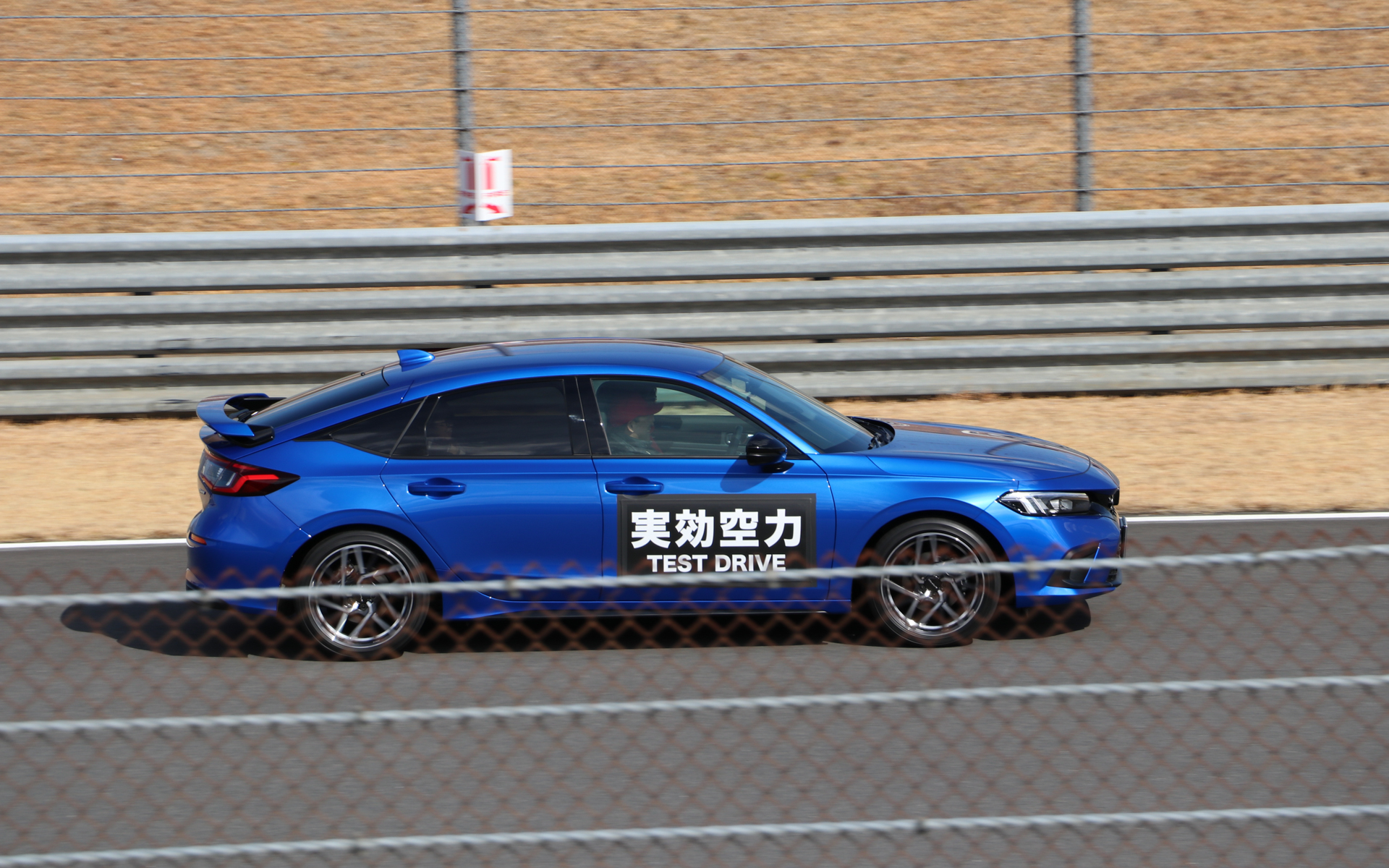 シビック専用テールゲートスポイラーを開発した山崎純平氏が助手席に乗って解説