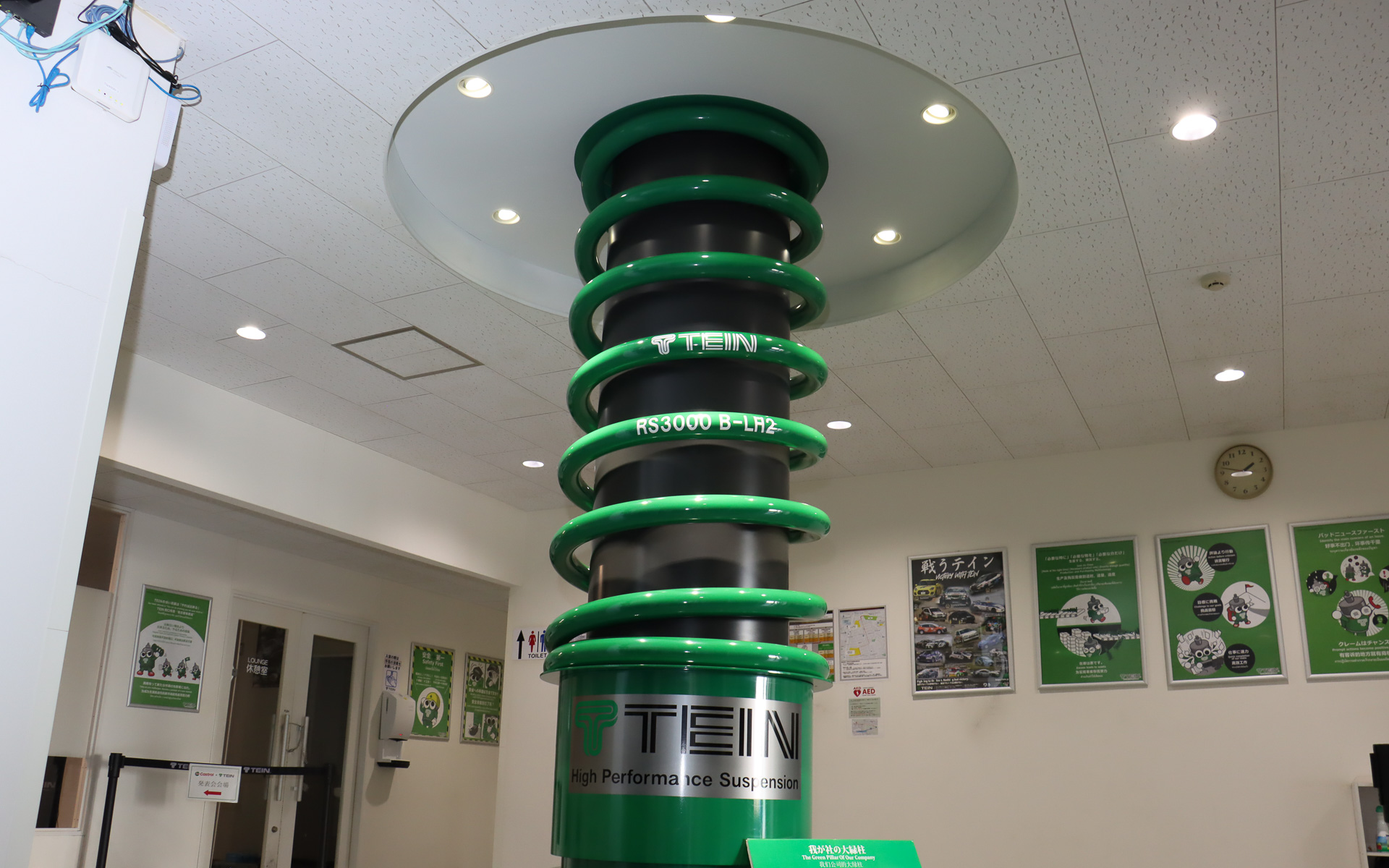 ロビーのかたわらにある、ダンパー＆スプリングを模した「我が社の大緑柱」。スプリングレートは「私達の壮大な夢を乗せて、走る続けられるくらい」とのこと