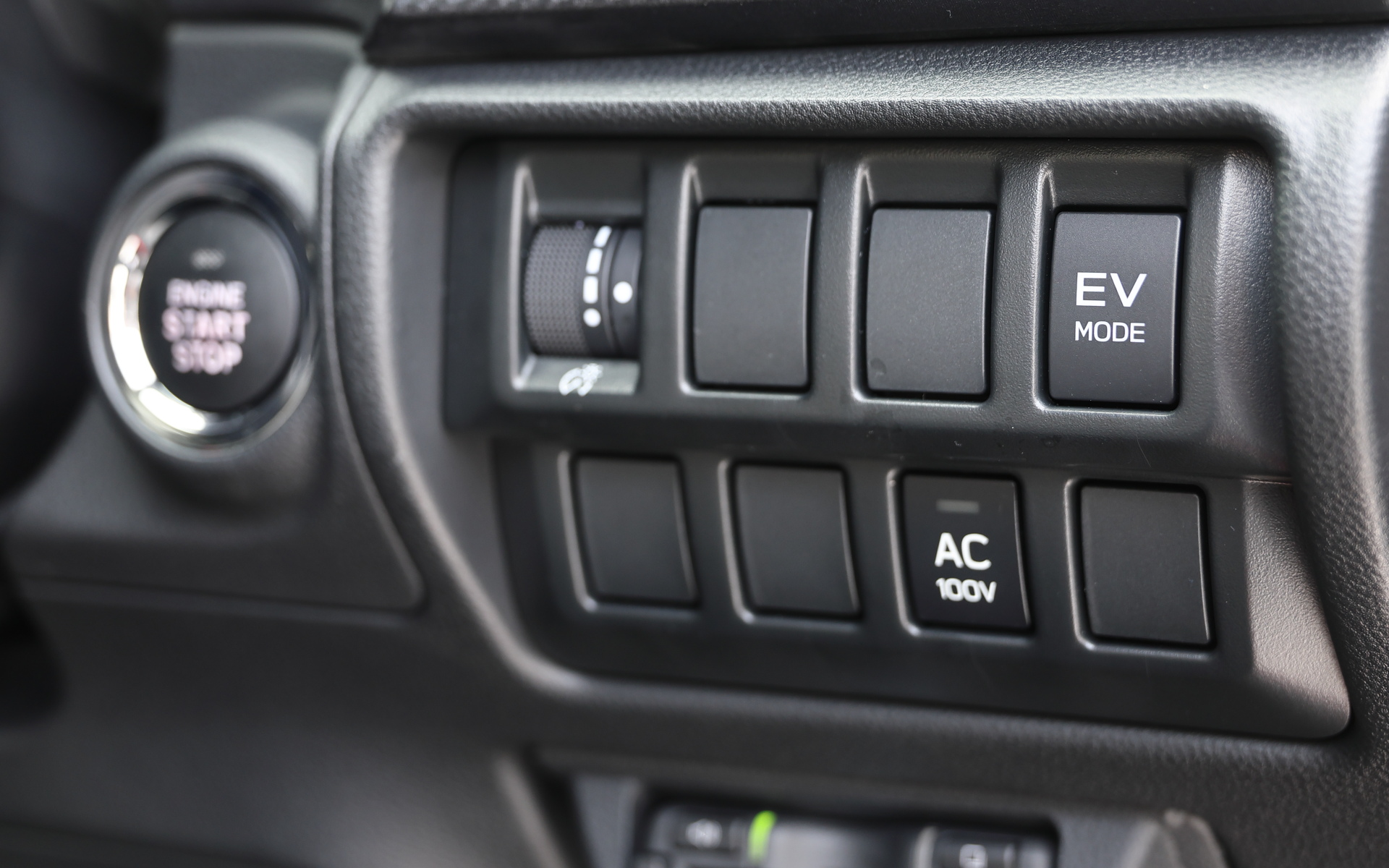 本革巻ステアリングホイール（シルバーステッチ/ブレイズガンメタリック加飾）のステアリングコラム右脇、キーレスアクセス＆プッシュスタートのスイッチ横に「EV MODE」スイッチと、メーカーオプション装備の「ACCコンセント」スイッチを配置
