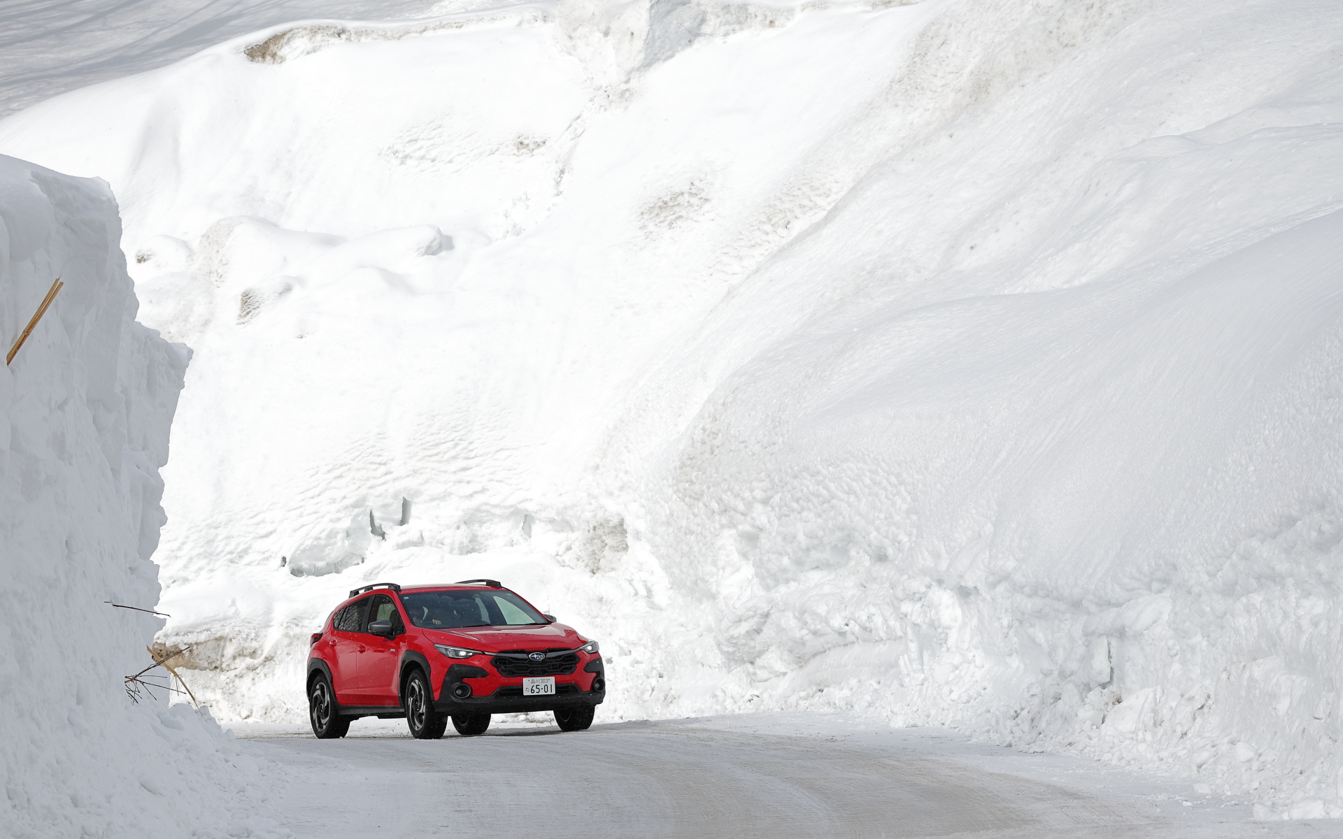 雪壁に囲まれた道を走るクロストレック S：HEV