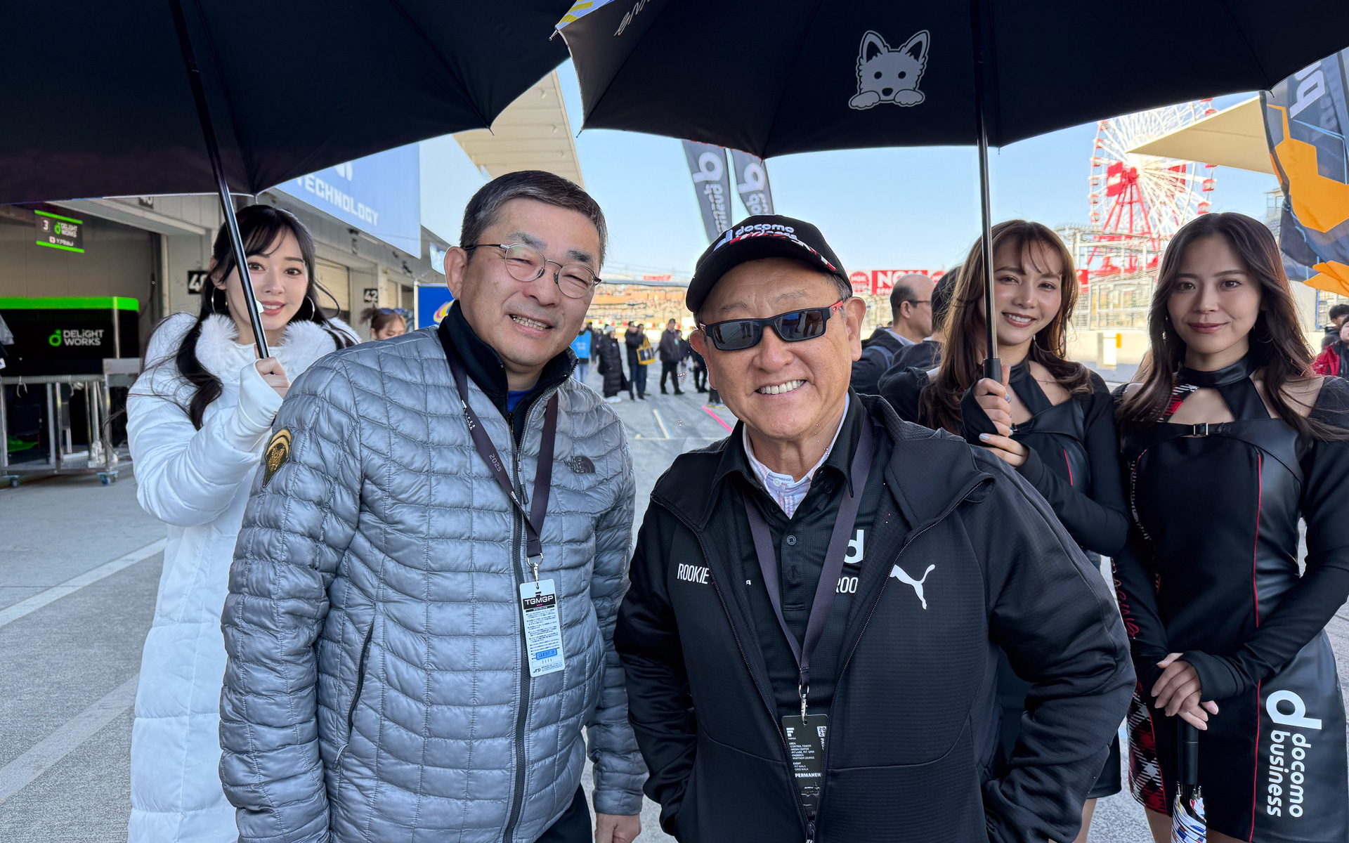 スペインから鈴鹿へ、新チームの応援にかけつけたKDDI株式会社 代表取締役社長 髙橋誠氏（左）。グリッドウォークでチーム設立のきっかけになったトヨタ自動車株式会社 代表取締役会長 豊田章男氏（右）とバッタリ