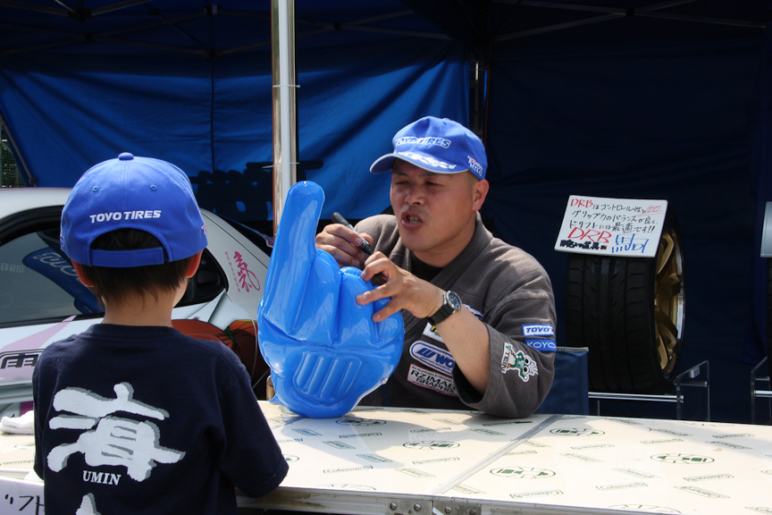 ブースでファンの子供にサインするドリフト侍