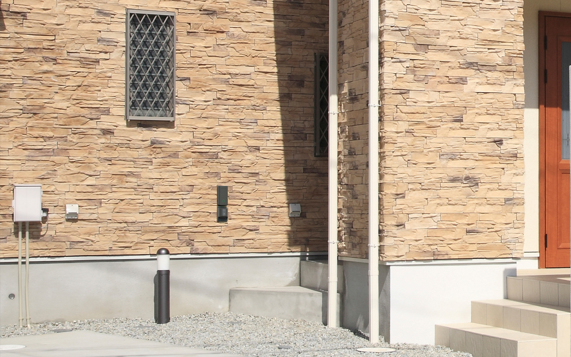 戸建て住宅にIoTモジュールと普通充電コンセントを設置したイメージ。茶色の壁についている縦長の黒っぽいものがそれだ