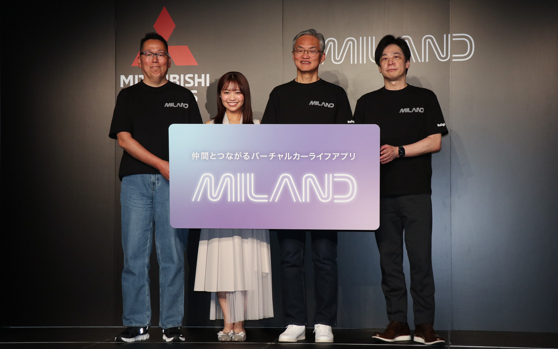 三菱自動車のドライブSNSアプリ「MILAND（ミランド）」発表会で行なわれたフォトセッション。左から三菱自動車工業株式会社 グローバルIT本部 デジタルイノベーション推進部 担当部長 伊藤卓朗氏、ゲスト出演した大原優乃さん、三菱自動車工業株式会社 代表執行役副社長 中村達夫氏、JP UNIVERSE株式会社 代表取締役 田畑端氏
