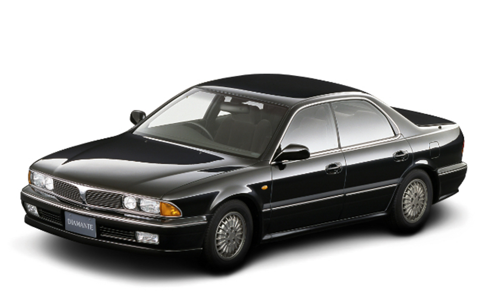 「ディアマンテ」。1990年に発売した初代モデル。4ドアハードトップ高級セダンで逆スラントノーズが特徴。小型車の枠を超えた3ナンバーサイズのボディと2.0リッター～3.0リッターエンジンをラインアップ。「HSR-II」で提案した先進技術のうち、4輪操舵やアクティブ電子制御サスペンションなどを採用