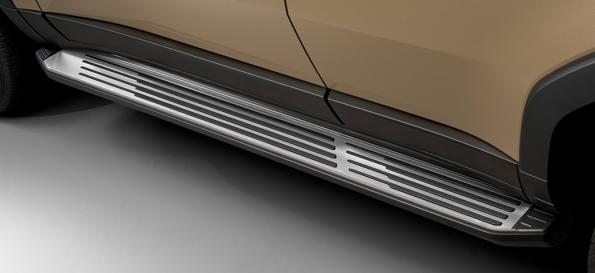 サイドステップメタルプレート：ステンレスの金属表現で、上質さ・洗練さを付与。足を掛けるエリアの大小をメリハリの効いたラインで表現することで機能と意匠の二律双生を図った