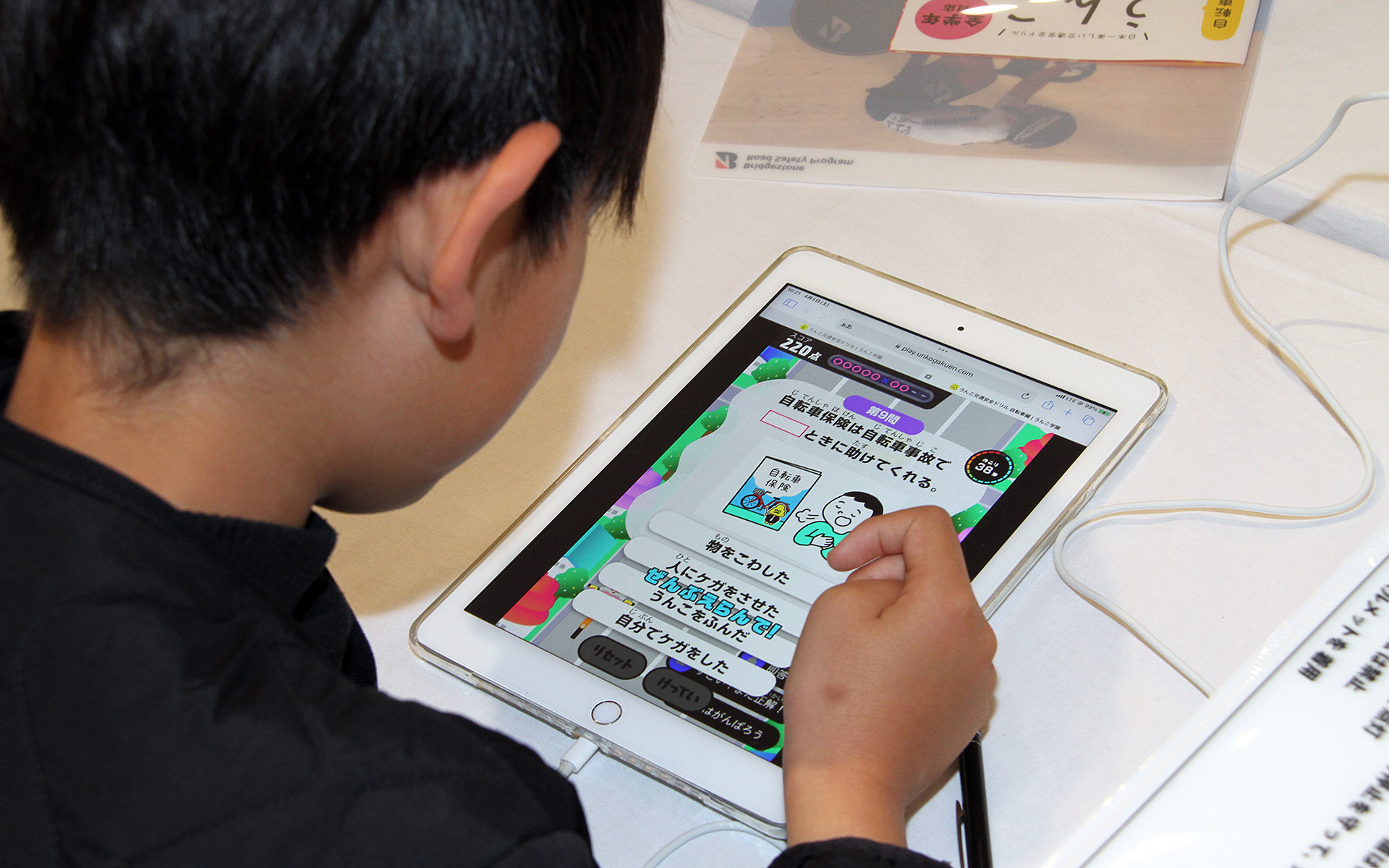 小学生が交通安全を楽しく学べる「うんこ交通安全ドリル」はテキスト版とタブレット版を用意。クリアファイルの配布も行なっていた