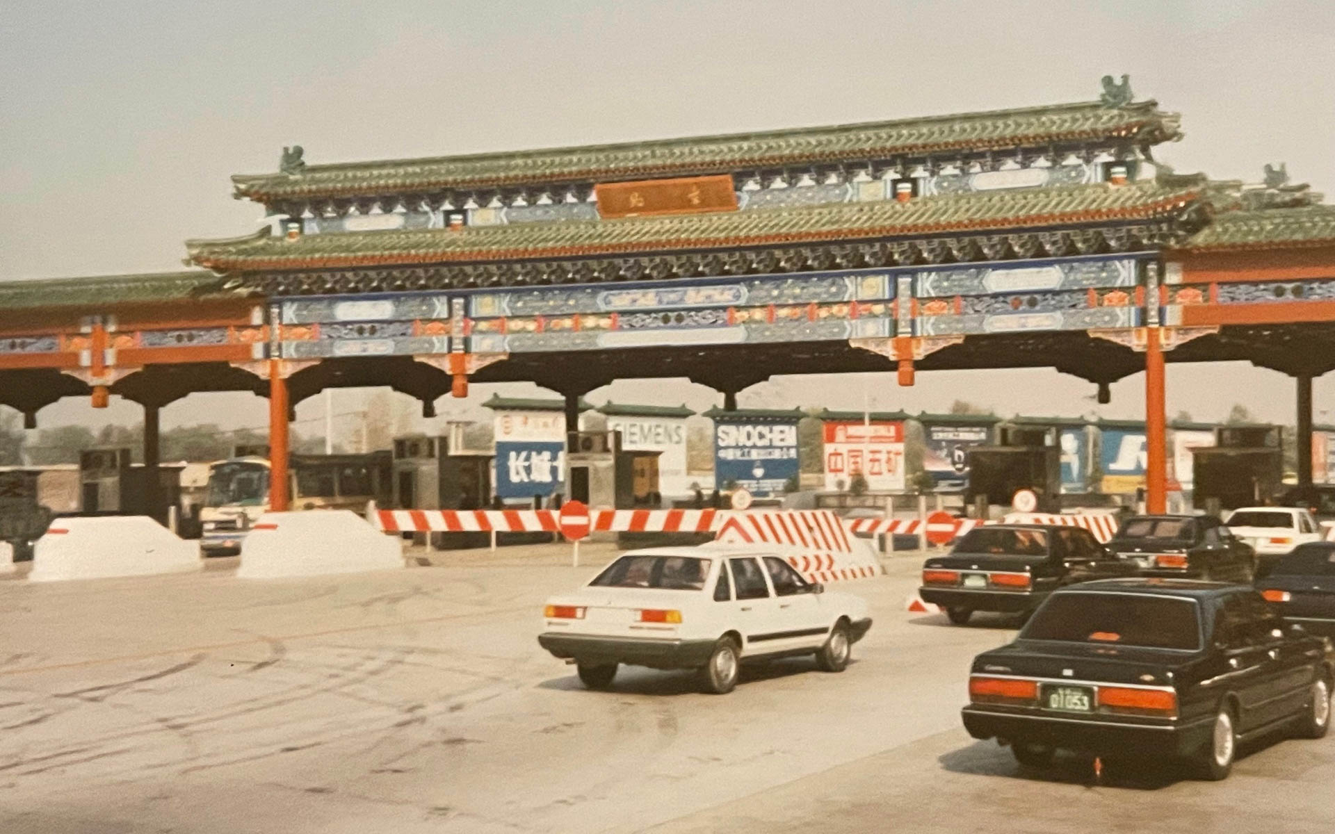 北京郊外の料金所（1993年）。鄧小平の改革開放のもと、急ピッチで整備された高速道路。料金所も中国風で風情があります。クルマも懐かしくノックダウンしていたサンタナが走っている。セドリックみたいだが詳細不明