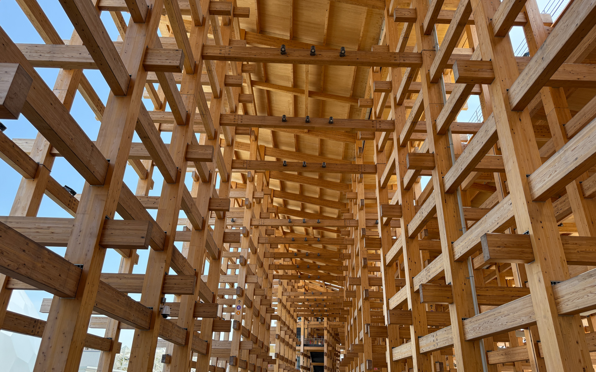 こちらは左が外側、右が内側。日本の神社仏閣などの建築に使用されてきた伝統的な貫（ぬき）接合に、現代の工法を加えて建築。会場の主動線として円滑な交通空間であると同時に、雨風、日差しなどを遮る快適な滞留空間として利用される