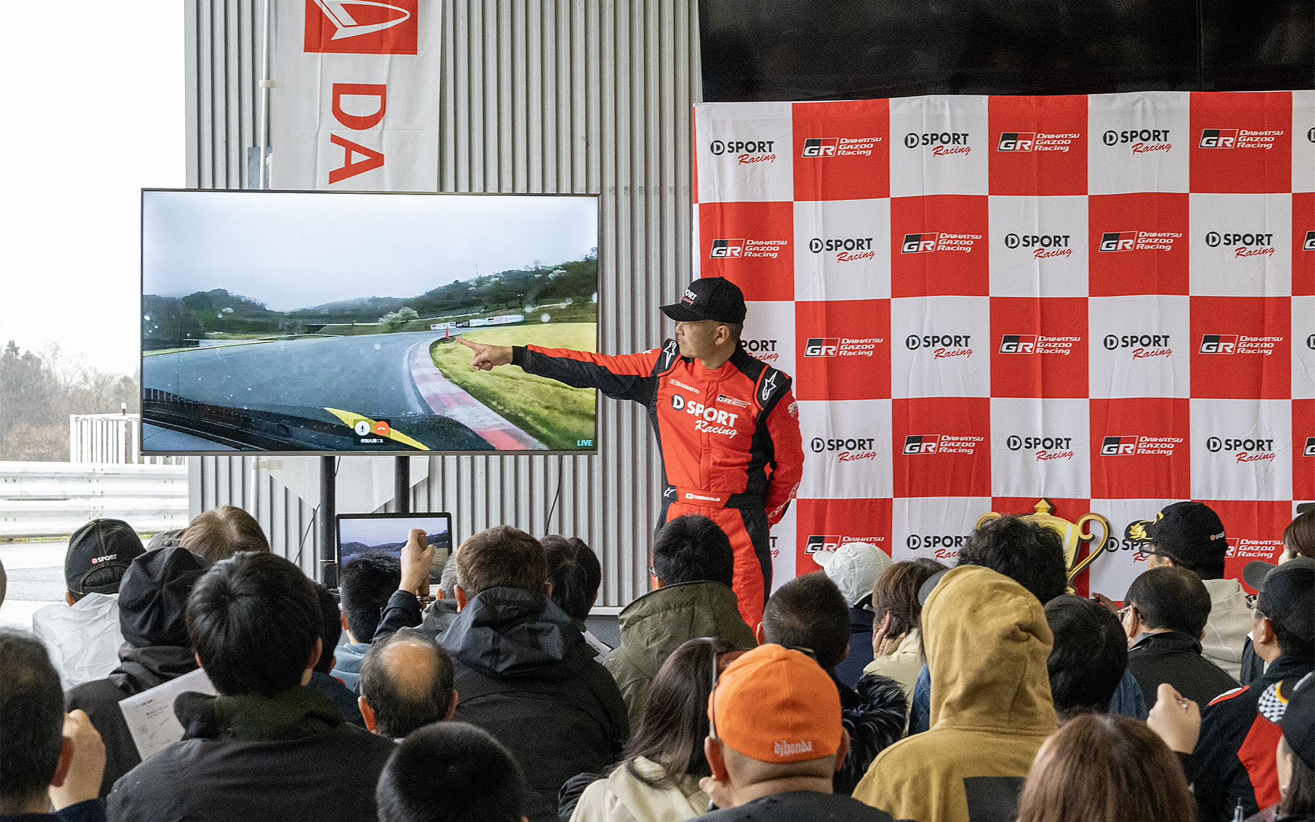 相原氏がドライブするクルマからの映像をモニターに映しながらポイントを解説。また、今回よりミニFMを使い、走行中の車内で聞けるライブ放送を開始。リアルタイムのアドバイスなどに役立つ取り組みだ