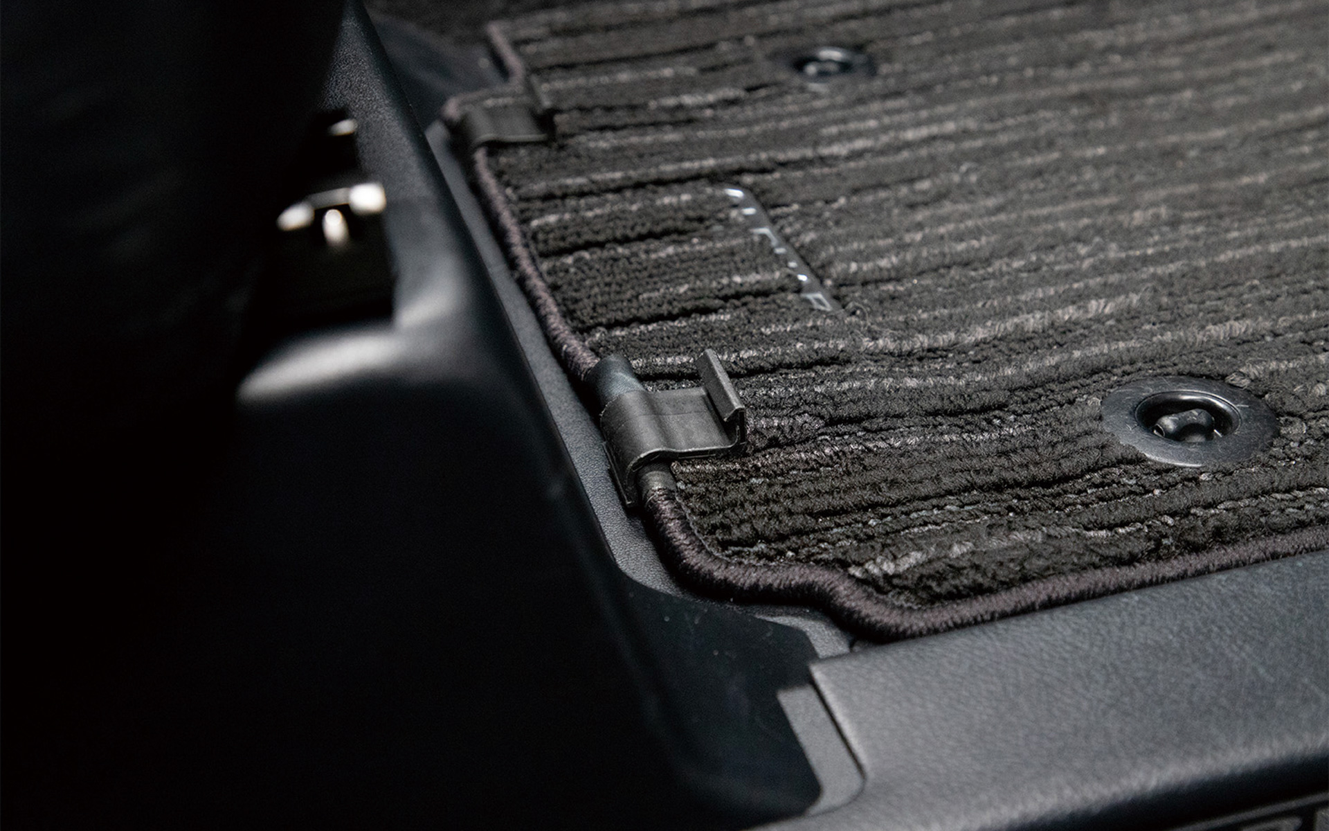 純正フロアマットをクルマに取り付け、マット固定用クリップを挟む。切れ目を入れた本体にマット固定用クリップを通して固定する