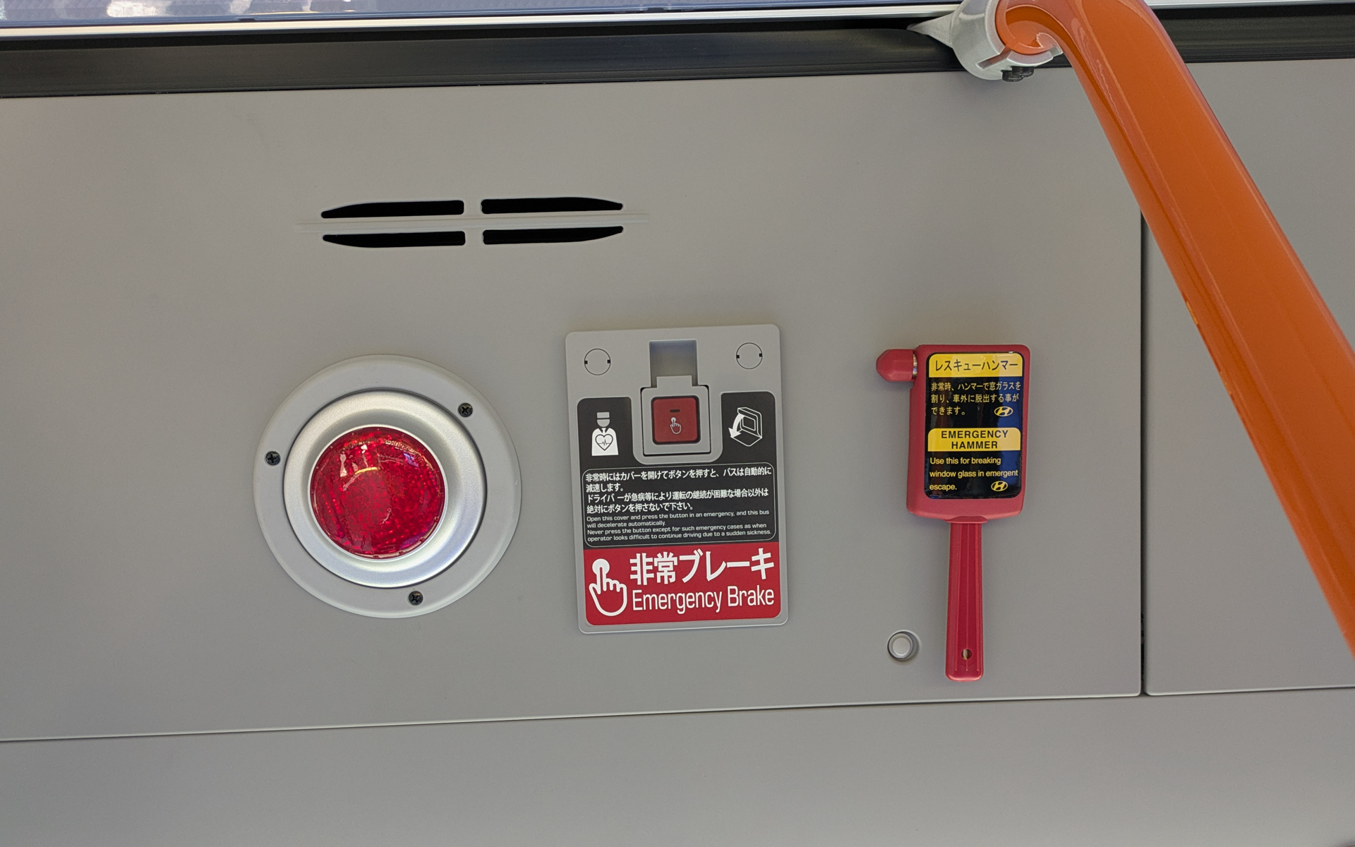乗客席側に設置されている緊急停止ボタン。窓を割るためのレスキューハンマーも備える