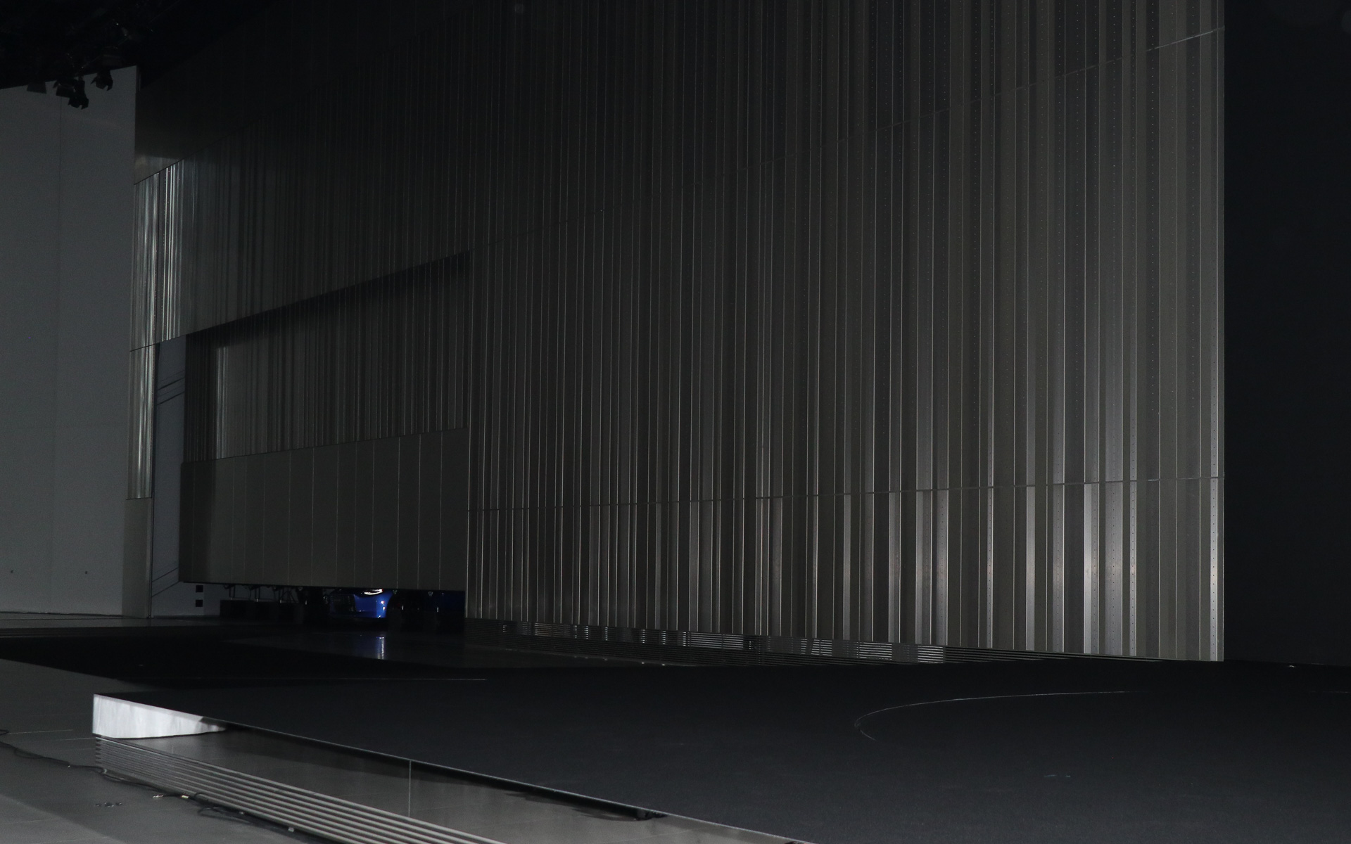 日産ホール側のシャッターが開いて「ワンガンブルー」の「フェアレディZ」が登場。ステアリングを握る鈴木さんはそのままゆっくりとフェアレディZを走らせ、日産グローバル本社ギャラリーのステージ上に上がった