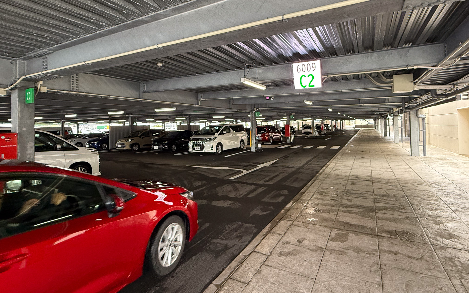 かんばん方式導入で待ち時間を劇的に短くしたトヨタレンタリース沖縄の取り組みを紹介。出発するレンタカーを駐車枠に移動する際、上部の液晶モニタで位置が表示される