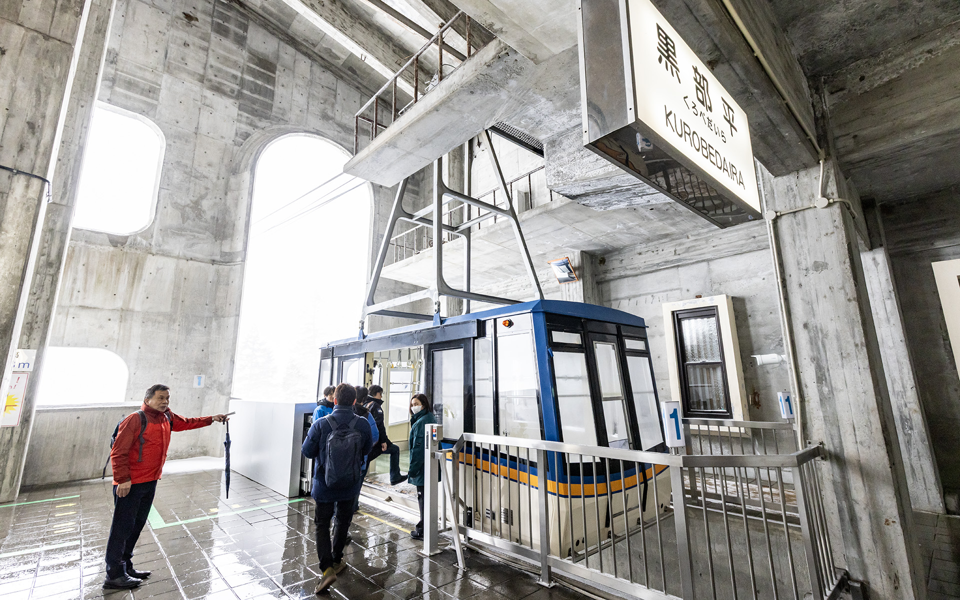 次に黒部平駅から大観峰駅までは立山ロープウェイで移動。この日は雪が降り続き景色を楽しむことはできなかったが、晴れた日には望外な景色が望めるに違いない。駅には「立山トンネル電気バス」のデビューをアナウンスするポスターも