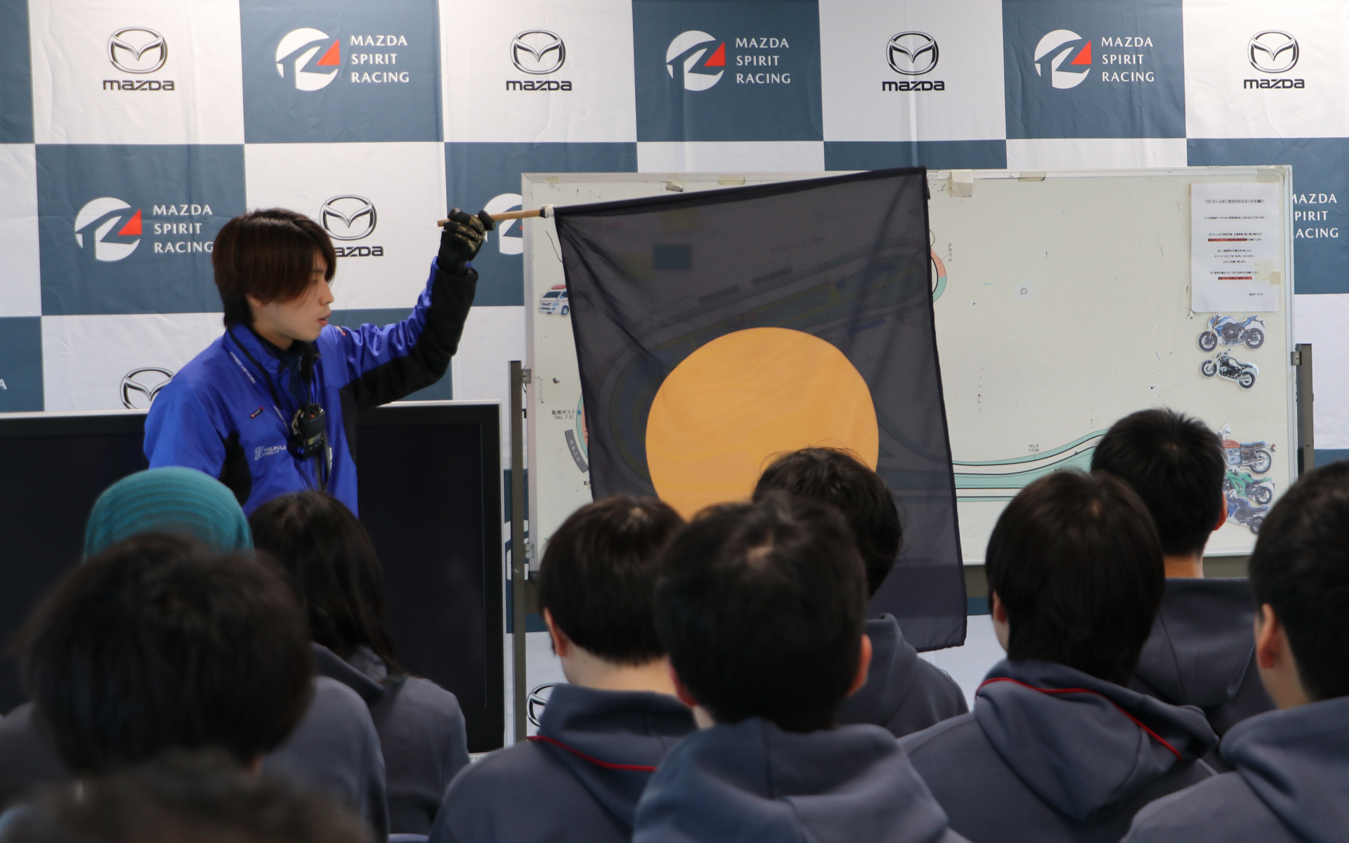 オレンジボール旗は、マシンに異常ありの合図。対象車のゼッケン番号と同時に掲示されるほか、マーシャルからも指差しされる。黒だけの旗ならそのまま走行してピットロードへ戻ればいいが、オレンジボールの場合はコースサイドなど安全な場所への車両の即時停止が求められる