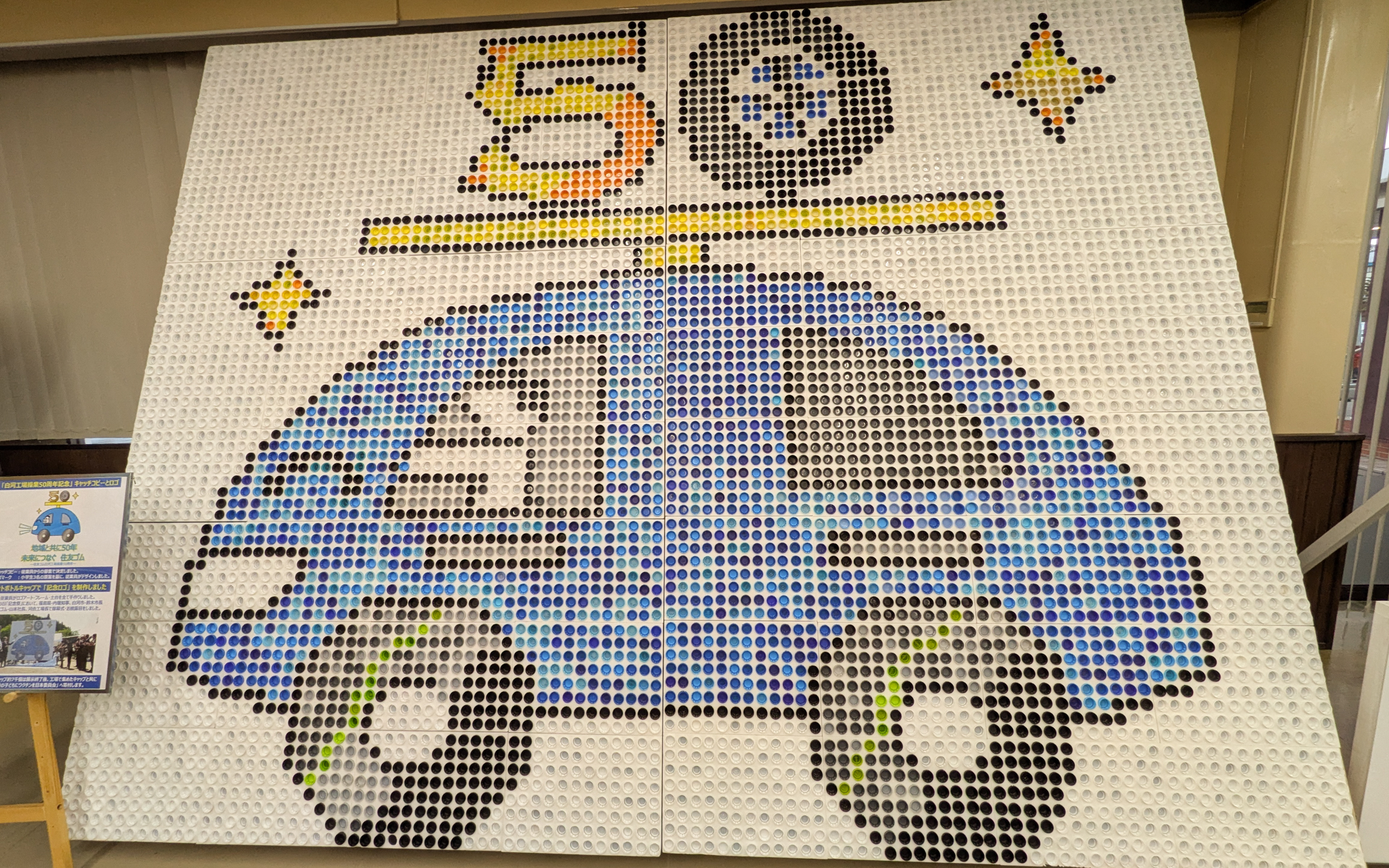 従業員から回収したペットボトルのキャップ7000個を使って制作したという記念ロゴのキャップアート