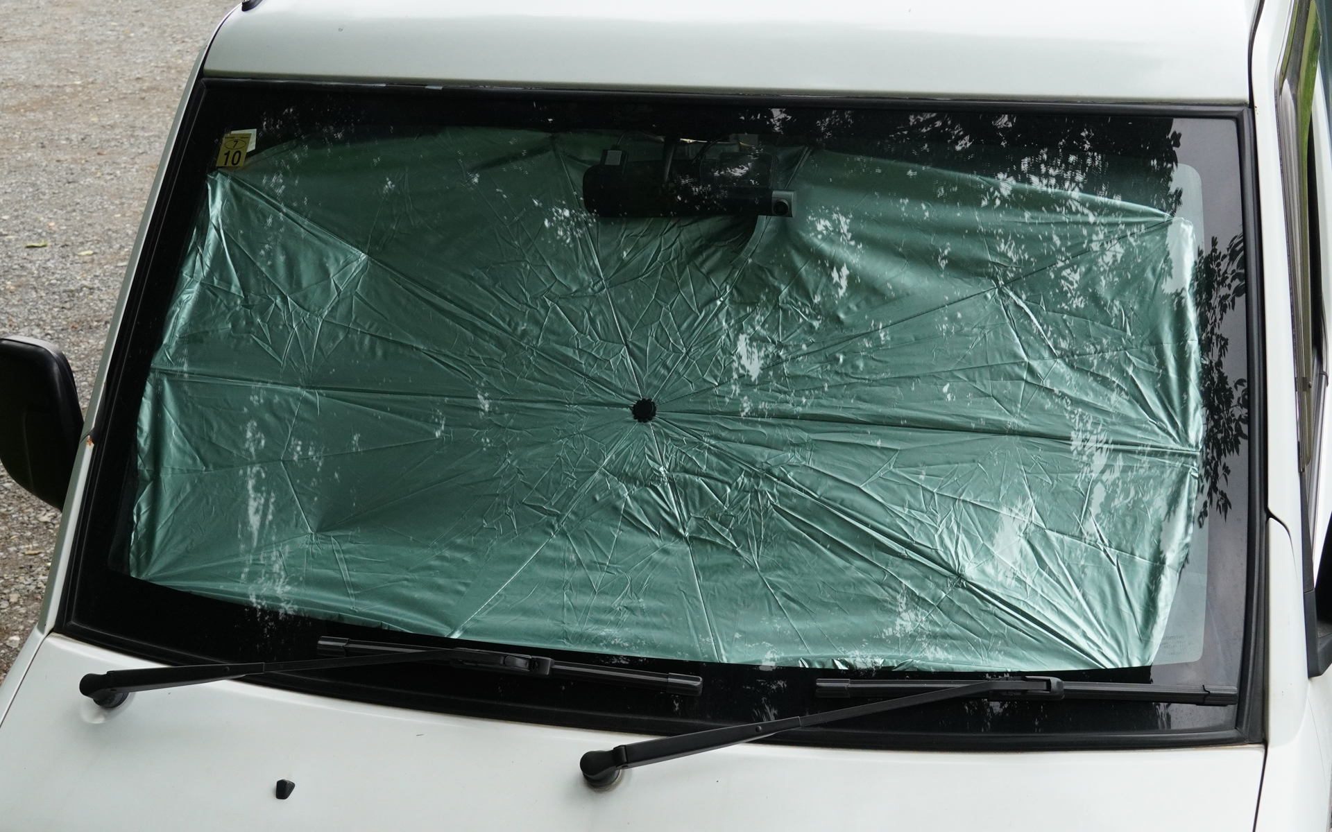 折りたたみ傘型のサンシェードを装着したところ。ドラレコを装着している場合は、サンシェードによってドラレコやメモリーカードが熱くなってしまい、故障の原因になる可能性があるので注意が必要