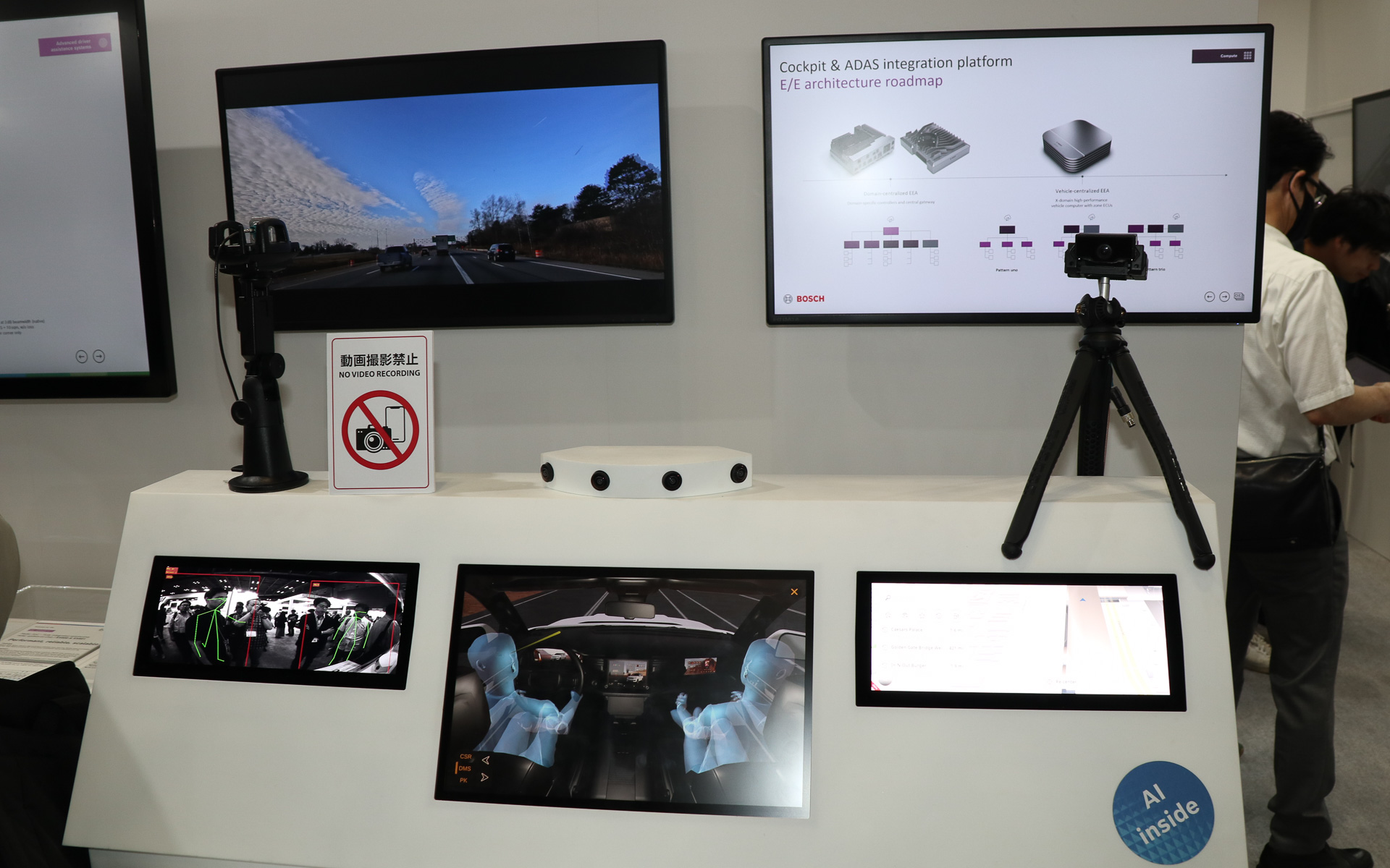 左下のデジタルメーターを模した画面でドライバー検知システムのデモを実施。通路側から展示内容を見学する人の姿勢をグリーンのラインで示している