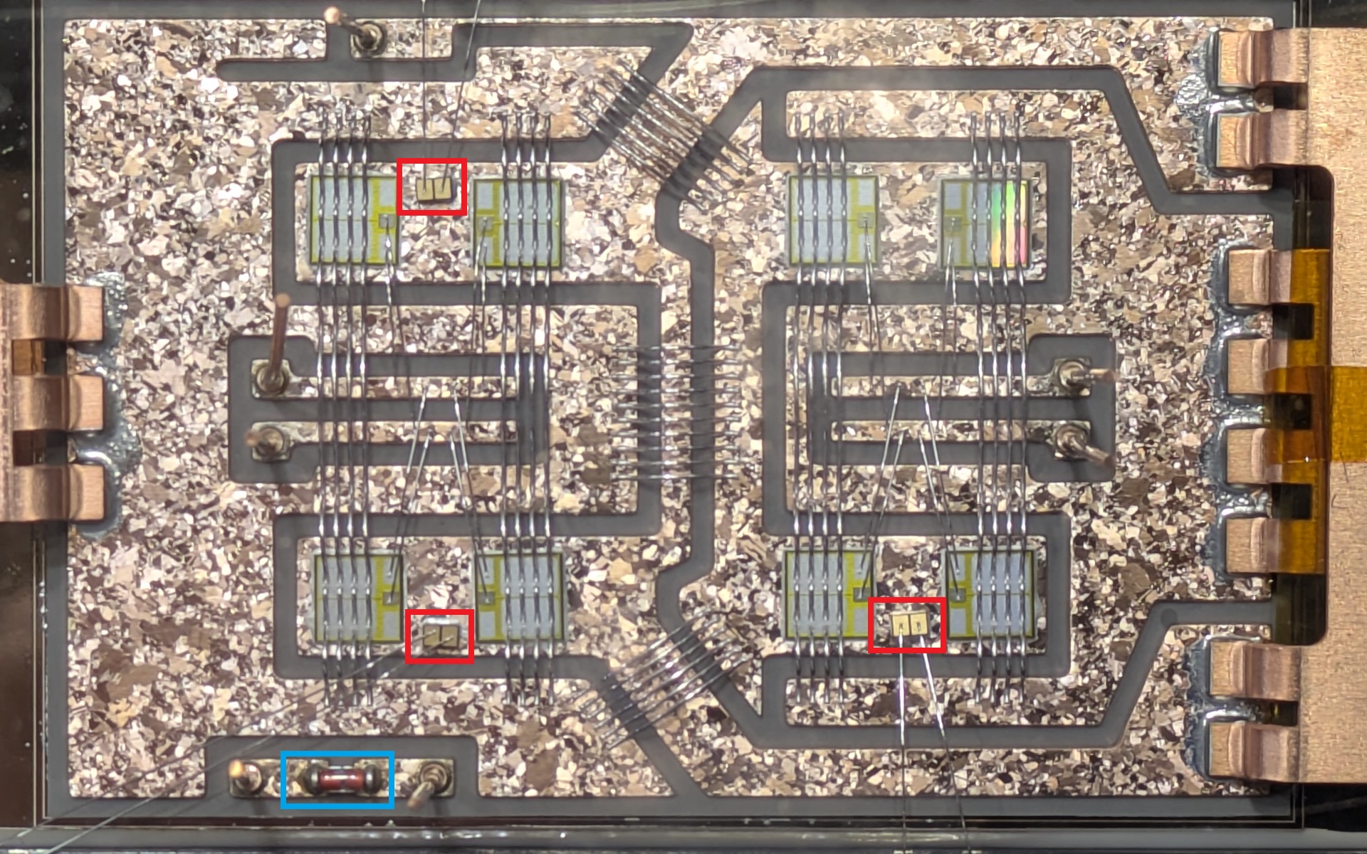 水色の四角が従来品のNTCサーミスタで、絶縁できないため離れた場所に設置するしかなかった。新製品となる赤い四角の絶縁型NTCサーミスタは、半導体のすぐ隣に設置しても正確に温度を計測して壊れないという
